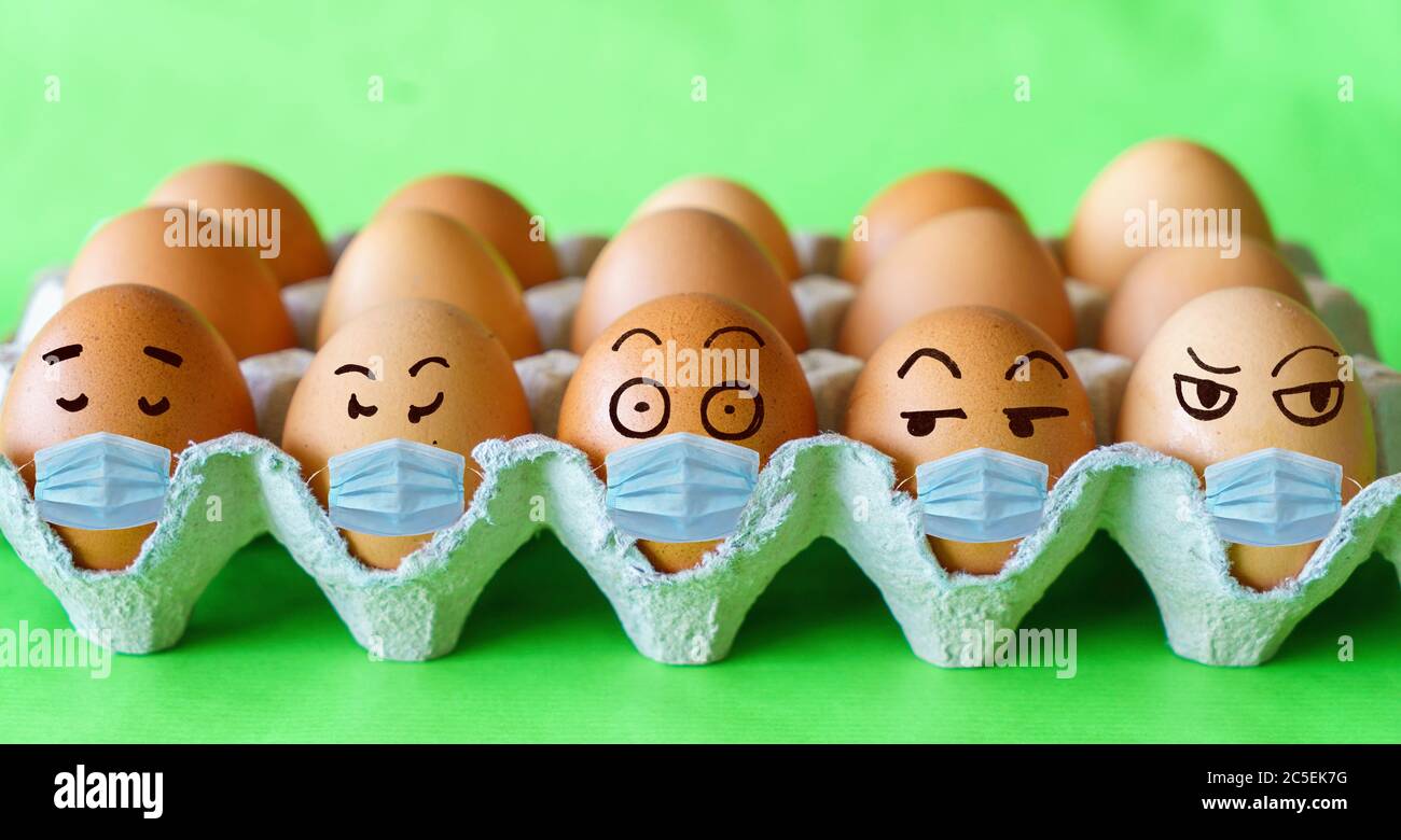 Volti sulle uova di pasqua con i concetti di protezione del virus della corona (COVID19). Uova di Pasqua che indossano la maschera. Concetto di protezione COVID-19. Foto Stock