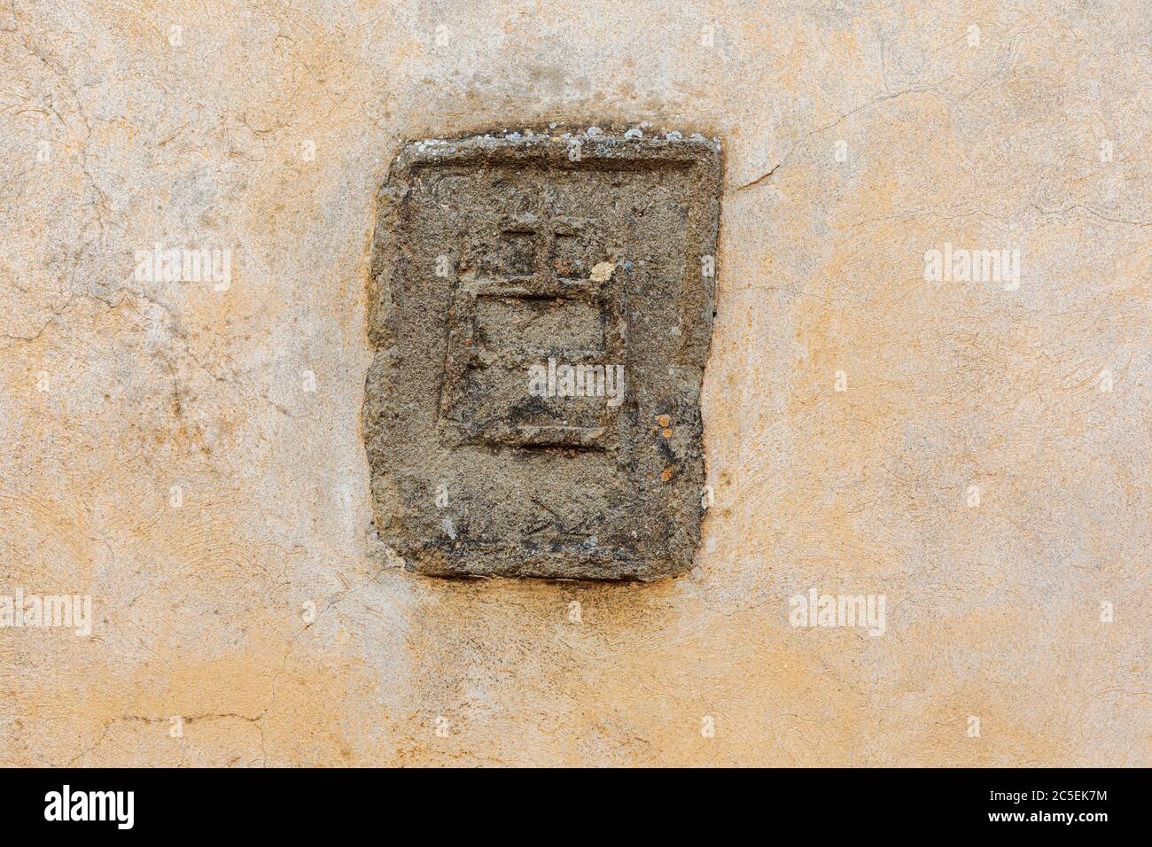 Simbolo di una pressa per vino posta nel muro di casa in vigneti in Toscana, Italia Foto Stock
