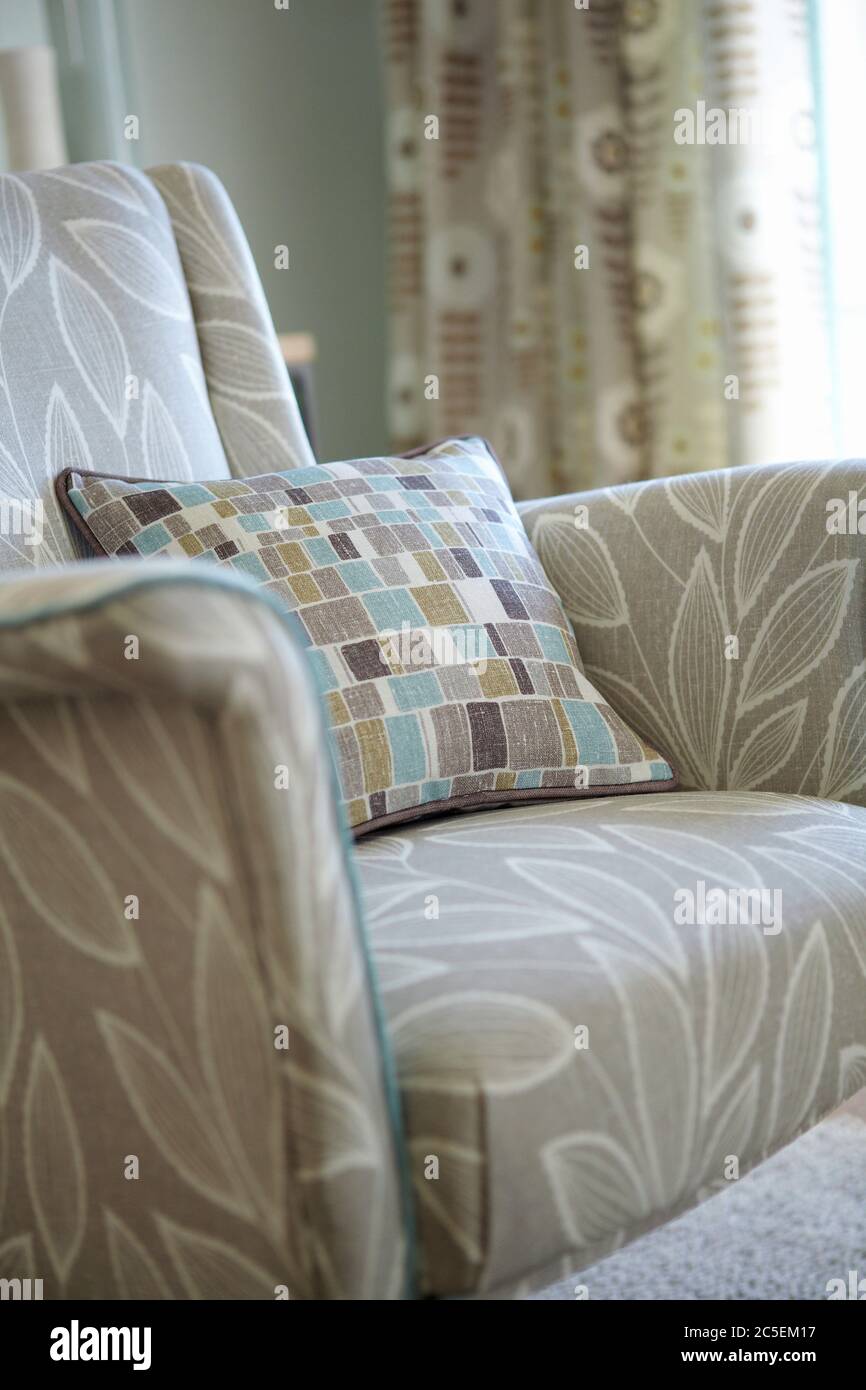 Nel moderno soggiorno sono presenti cuscini multicolore sulla poltrona Foto Stock