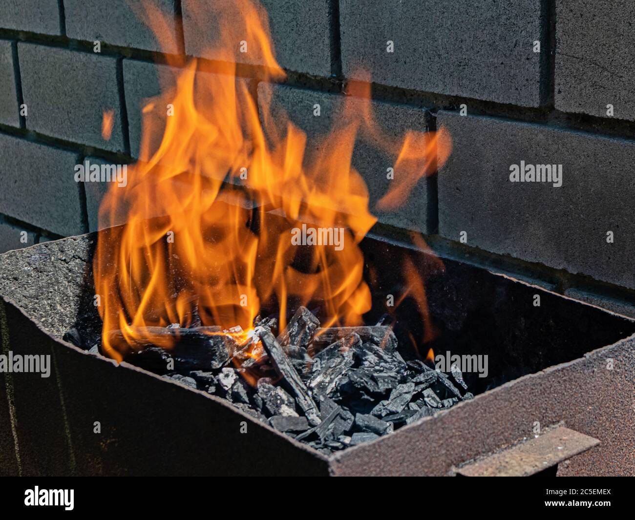 Vivace barbecue arancione fiamma su brandeli calici in attesa di fare barbecue Foto Stock