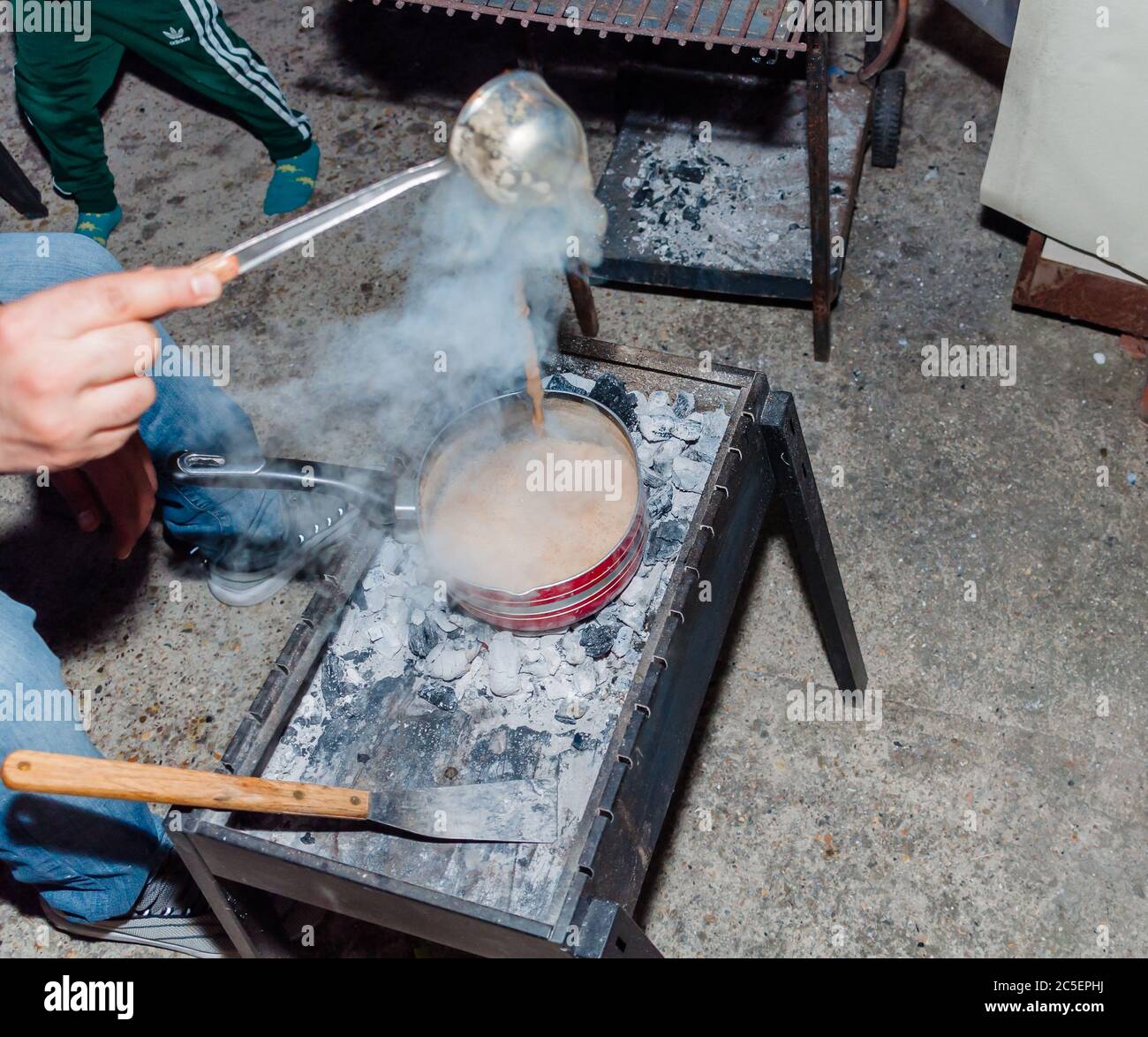 Tè al latte caldo di stile pakistano o Chai sopra carbone con pentola del tè Foto Stock