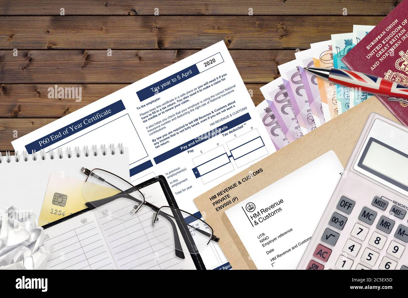 Inglese modulo fiscale P60 certificato di fine anno da HM entrate e dogane si trova sul tavolo con gli articoli per ufficio. Documentazione HMRC e procedura di pagamento delle tasse in Unite Foto Stock