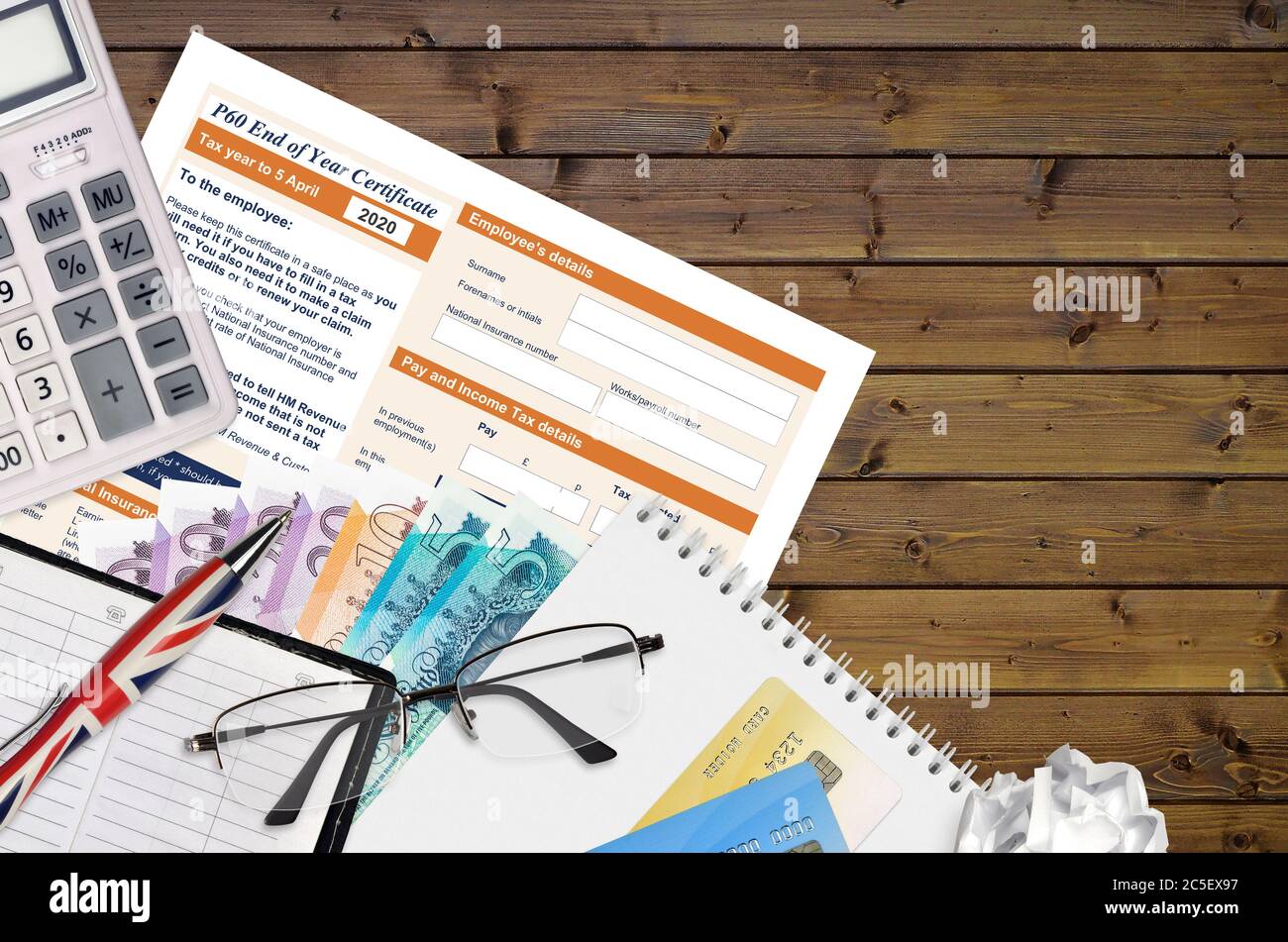 Inglese modulo fiscale P60 certificato di fine anno da HM entrate e dogane si trova sul tavolo con gli articoli per ufficio. Documentazione HMRC e procedura di pagamento delle tasse in Unite Foto Stock