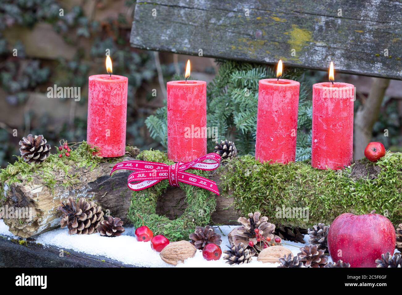 decorazione di natale con candele di avvento rosse sul vecchio tronco dell'albero Foto Stock