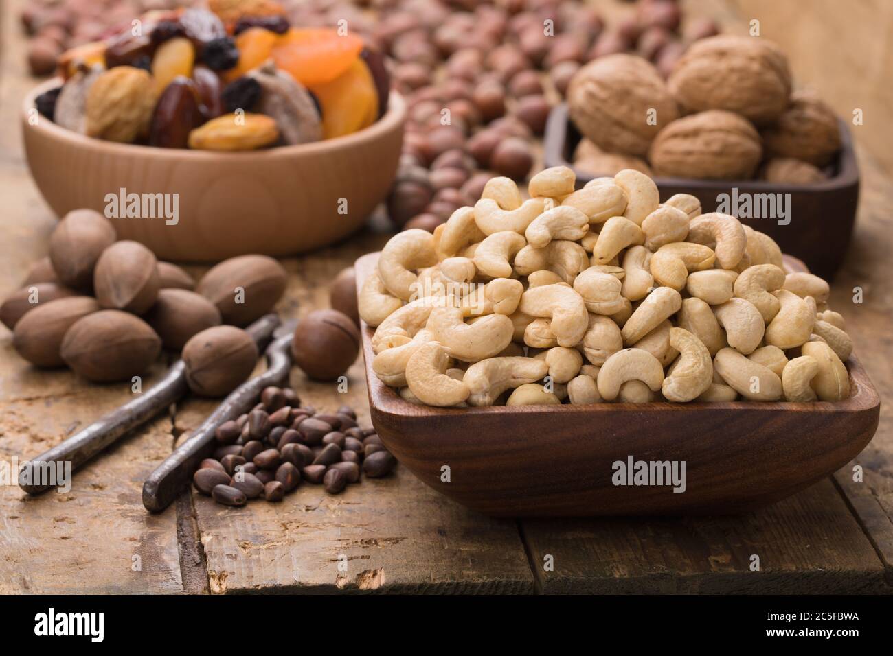 noci di anacardi sbucciate crude in ciotola su tavola di legno. Alimenti utili per vegetariani e vegani. Foto Stock