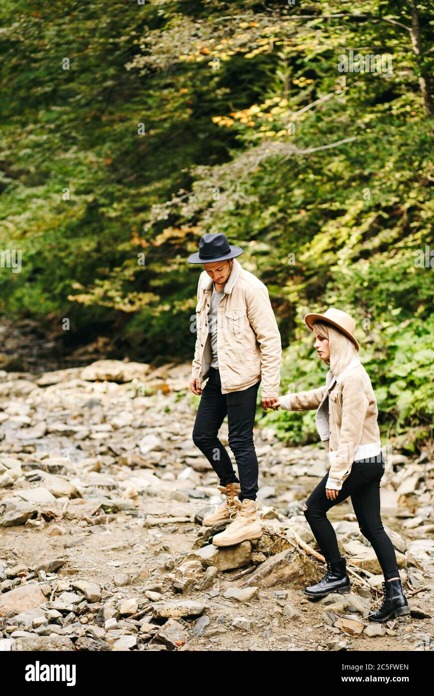 Giovane coppia al Carpazi - turisti felici in visita in montagna. Lovestory. Turisti in cappelli. Moda militare Foto Stock