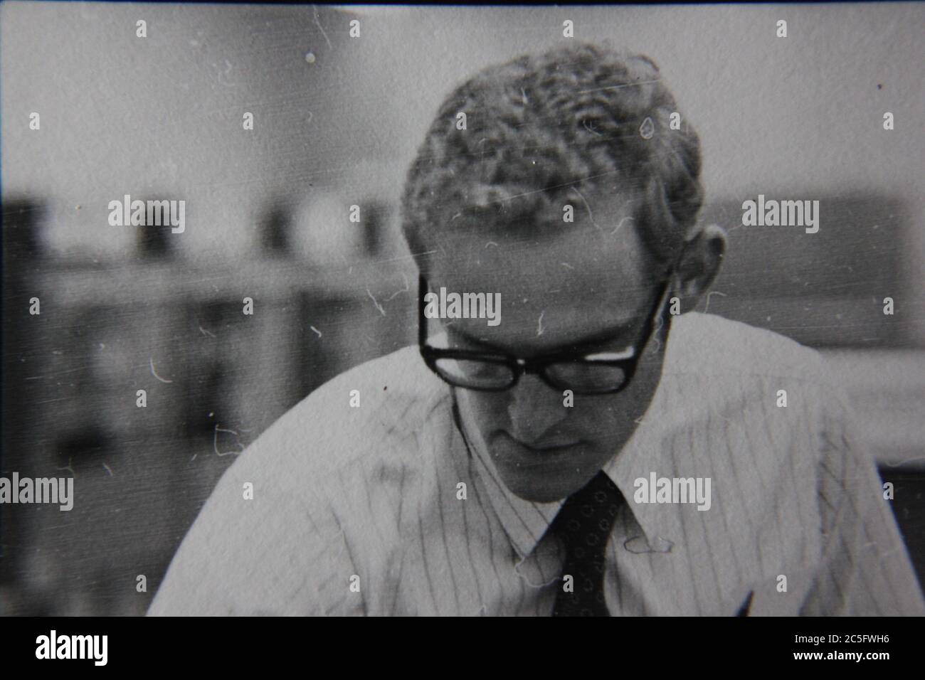 Fine anni '70 vintage nero e bianco stile di vita fotografia di un uomo che lavora in ufficio per affari. Foto Stock