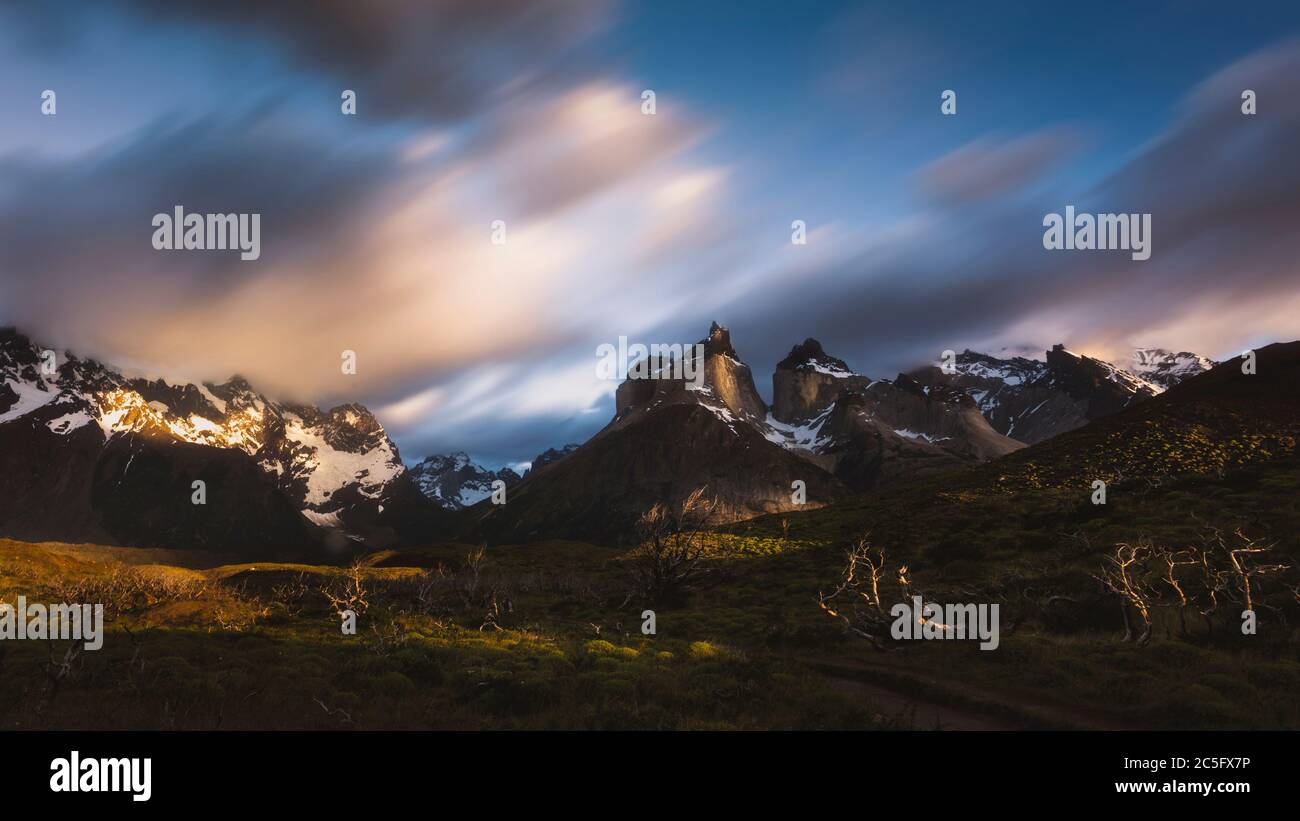 Luce solare frugata sulle cime del massiccio paino, con nuvole che si stagliano sopra Foto Stock