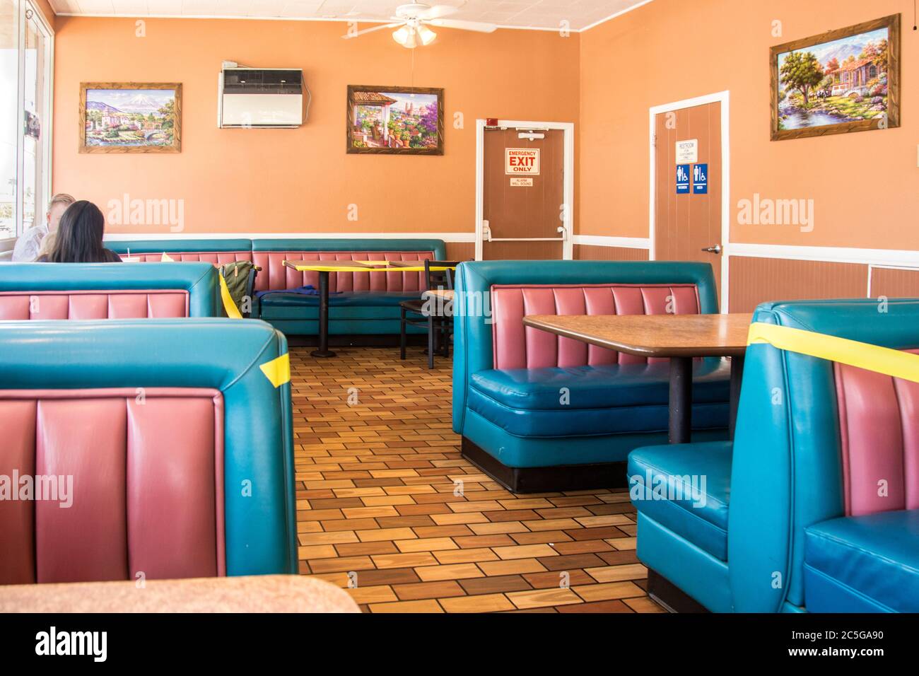 Un'area di un ristorante che è stata chiusa per mantenere la distanza sociale appropriata in risposta al virus COVID19. Foto Stock