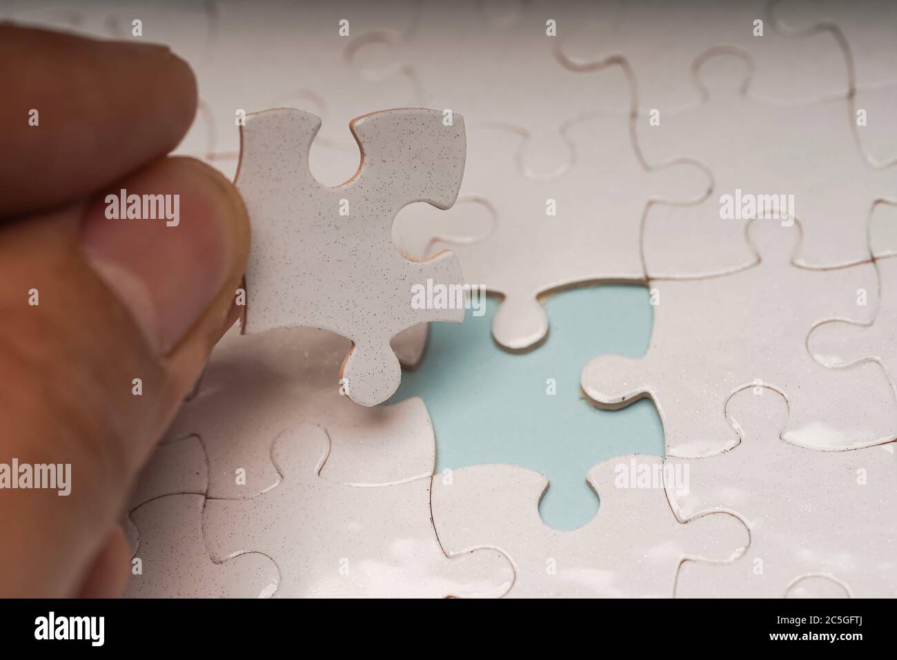 Foto chiusa di pezzi di puzzle bianchi vuoti, messa a fuoco selettiva, spazio di copia per il testo Foto Stock