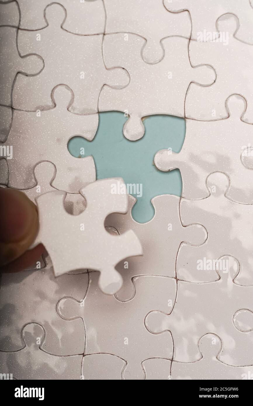 Foto chiusa di pezzi di puzzle bianchi vuoti, messa a fuoco selettiva, spazio di copia per il testo Foto Stock