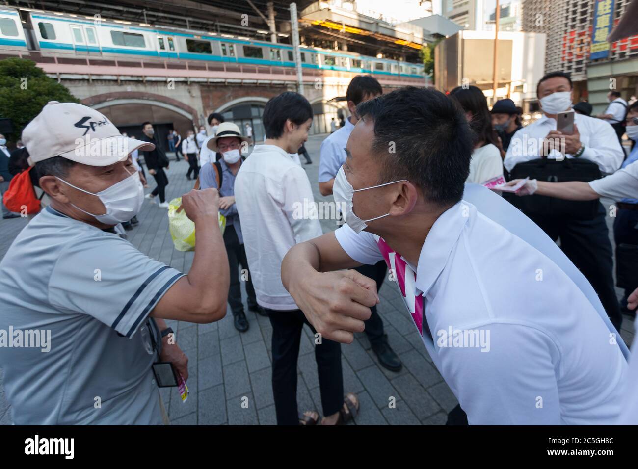 L'ex attore Taro Yamamoto, leader del partito politico anti-establishment Reiwa Shinsengumi, tocca i gomiti con i sostenitori mentre electioneering a Shimbashi per le elezioni gubernatoriali di Tokyo del 2020. Tokyo, Giappone. Giovedì 2 luglio 2020. Le elezioni per il governatore di Tokyo si svolgono domenica 5 luglio. La ex-presidente, Yuriko Koike (non raffigurata) si aspetta che vinca facilmente la rielezione per il suo secondo mandato come leader della capitale giapponese. Foto di Damon Coulter/AFLO Foto Stock