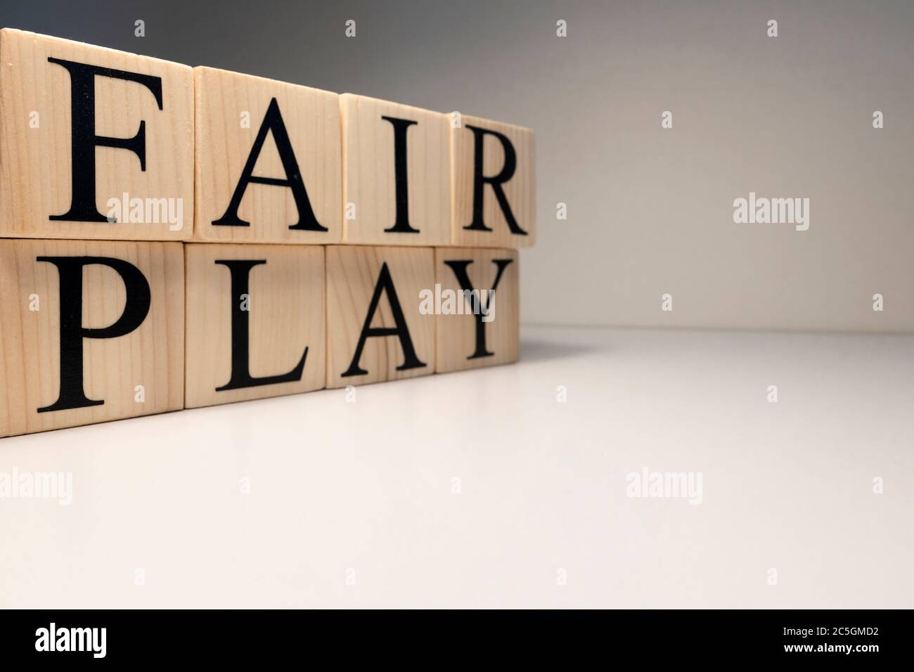 Parola di gioco giusta da cubi di legno. Faretto e sfondo bianco. Foto Stock