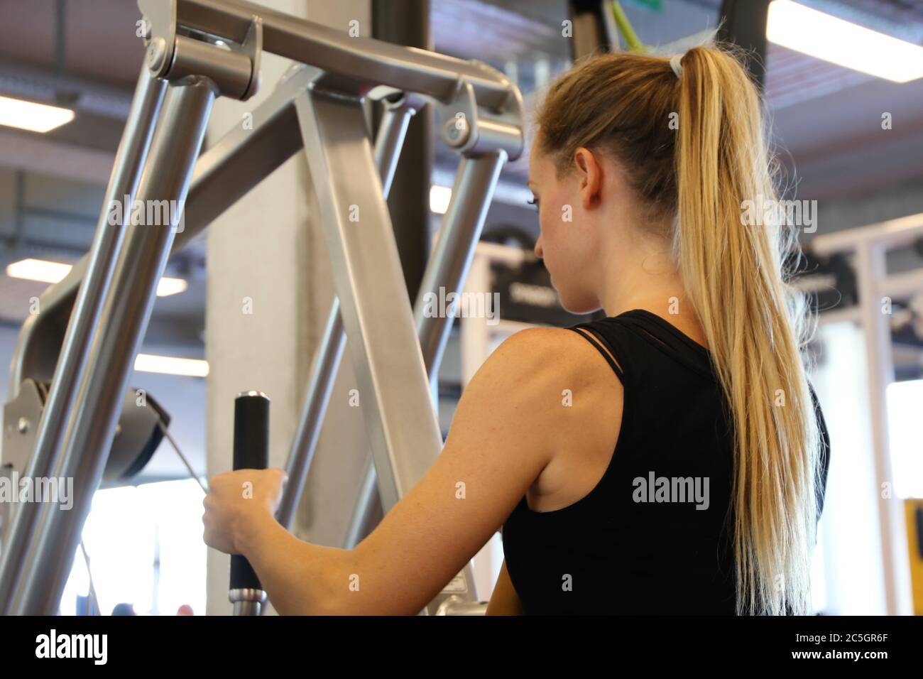 Junge Frau beim Gerätetraining Fitnessstudio (modello rilasciato) Foto Stock