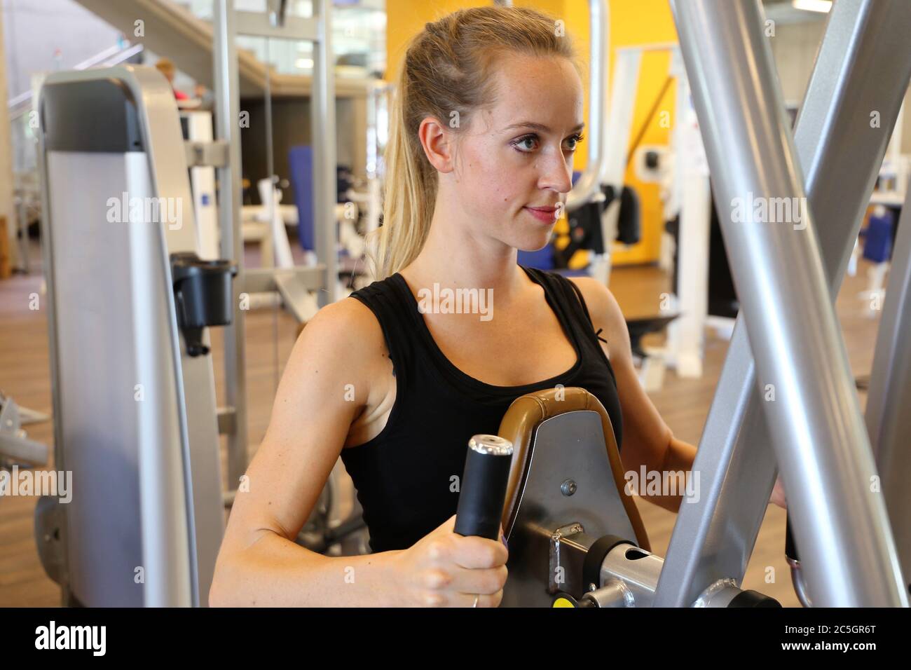 Junge Frau beim Gerätetraining Fitnessstudio (modello rilasciato) Foto Stock