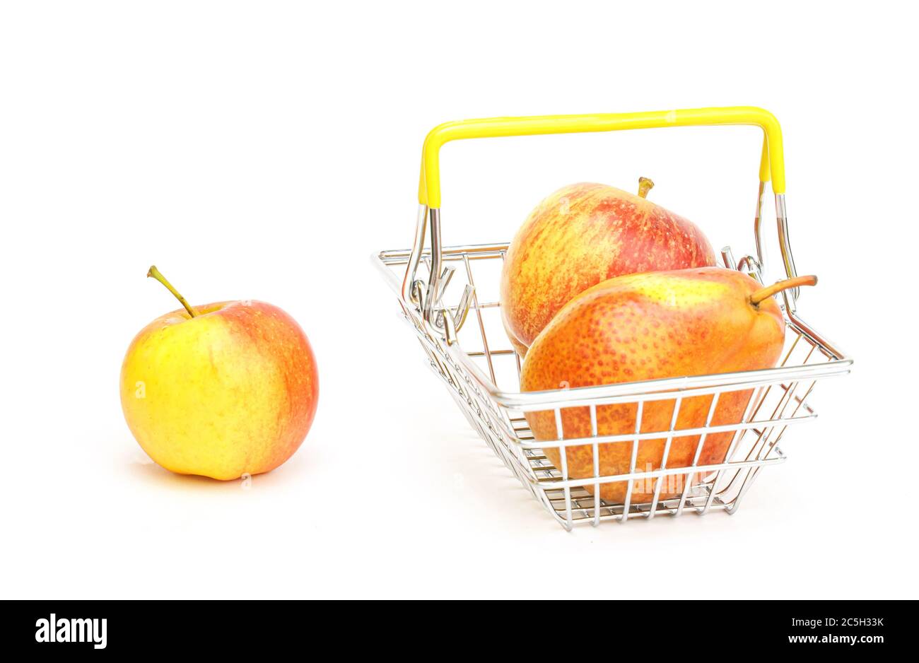 un piccolo cestino con frutta, mele, pere su sfondo bianco. Cibo sano, cibo vegetariano, verdure, shopping al supermercato. Foto Stock