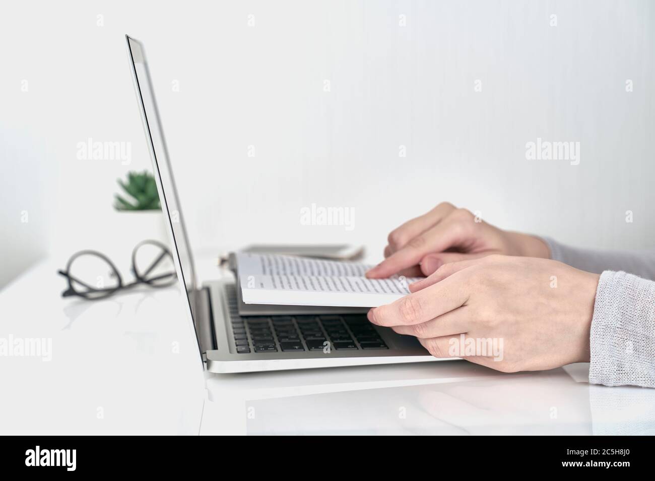 Donna che cerca informazioni nel libro, concetto di lavoro di ufficio su sfondo bianco parete Foto Stock