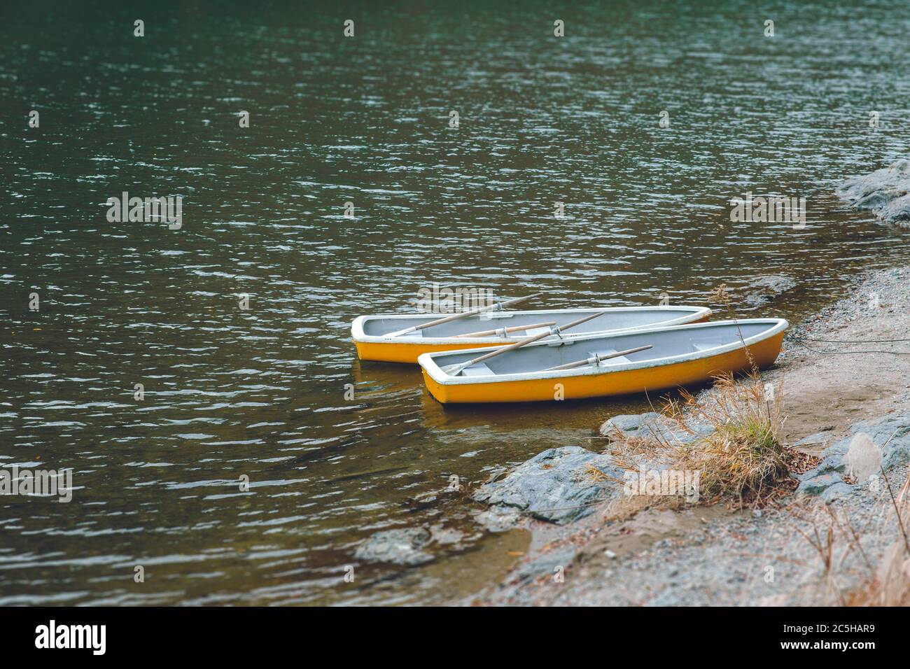 Due barche di legno senza persone in un lago tranquillo, nessun viaggiatore e impatto turistico di Coronavirus (COVID-19) focolaio Foto Stock