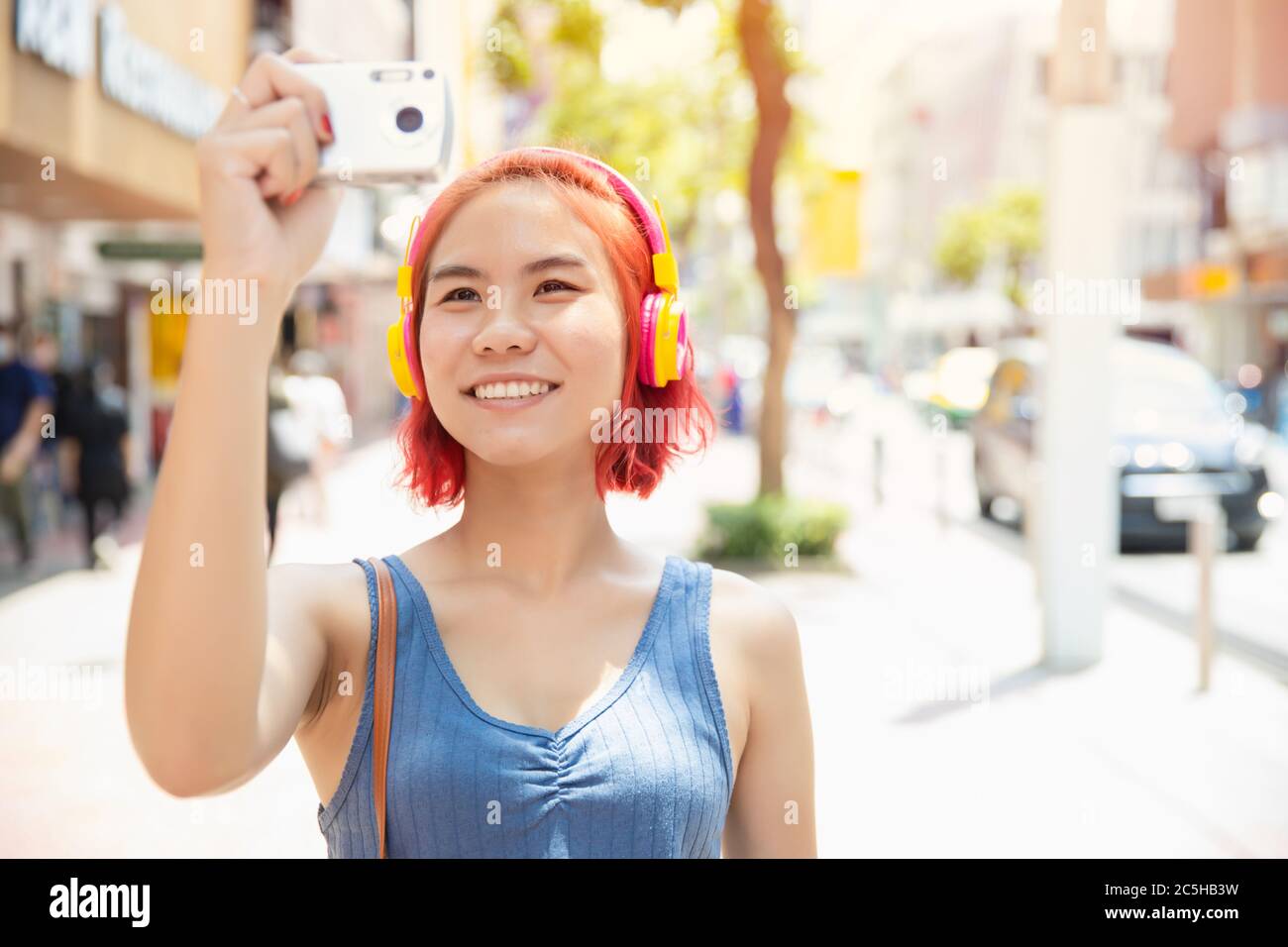 Ragazza asiatica teen sorriso felice di viaggiare con la fotocamera scattare una foto intorno alla città all'aperto stagione estiva Foto Stock