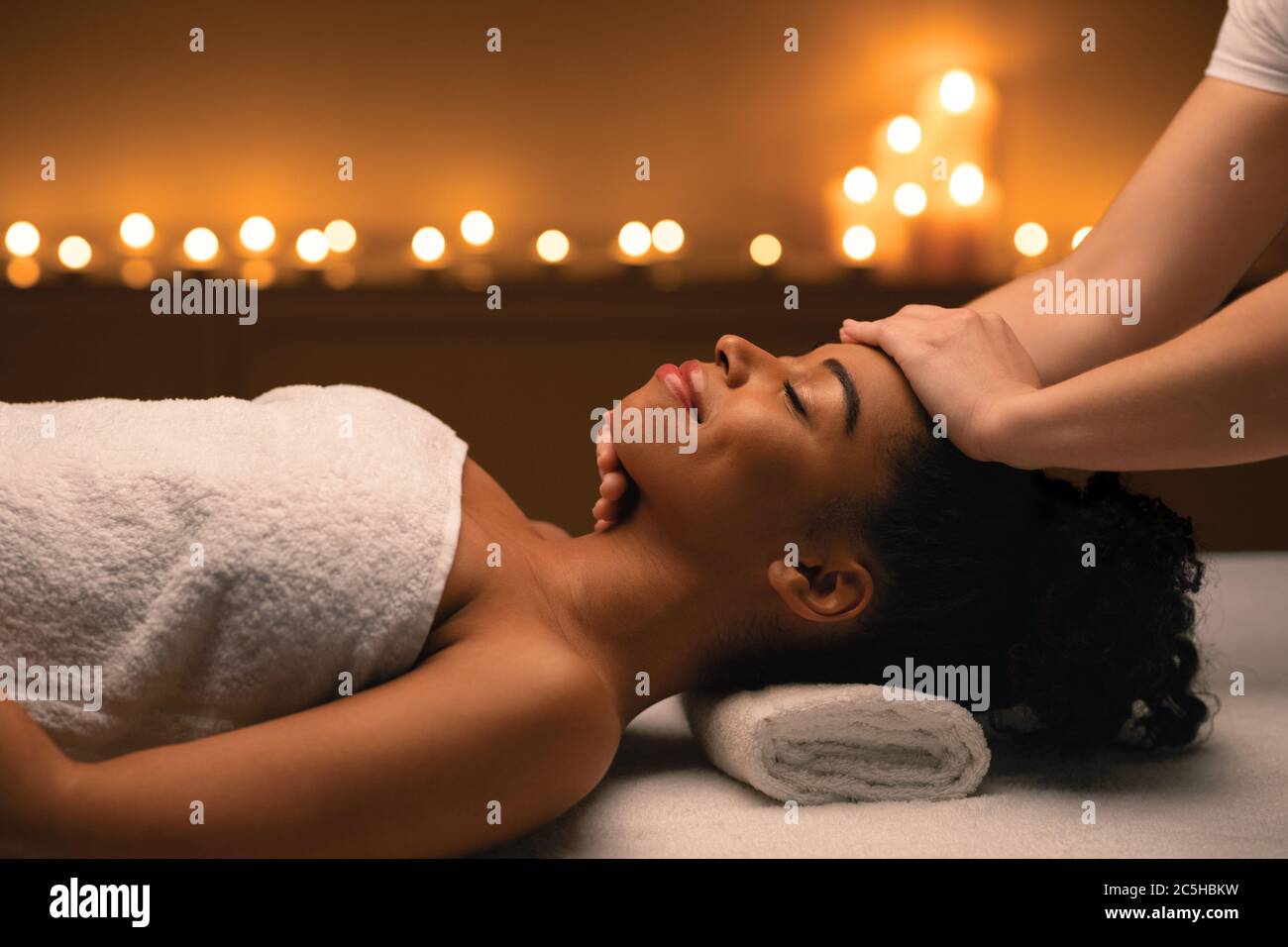 Massaggio di scultura del viso per bella donna afroamericana Foto Stock