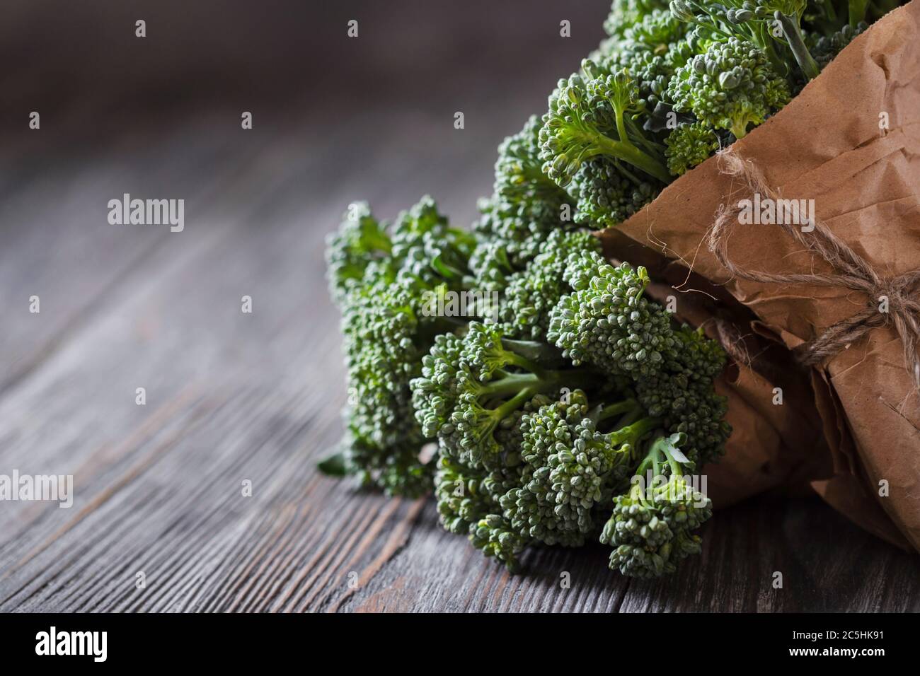 Due mazzetti di broccolini su tavolo di legno. Foto Stock