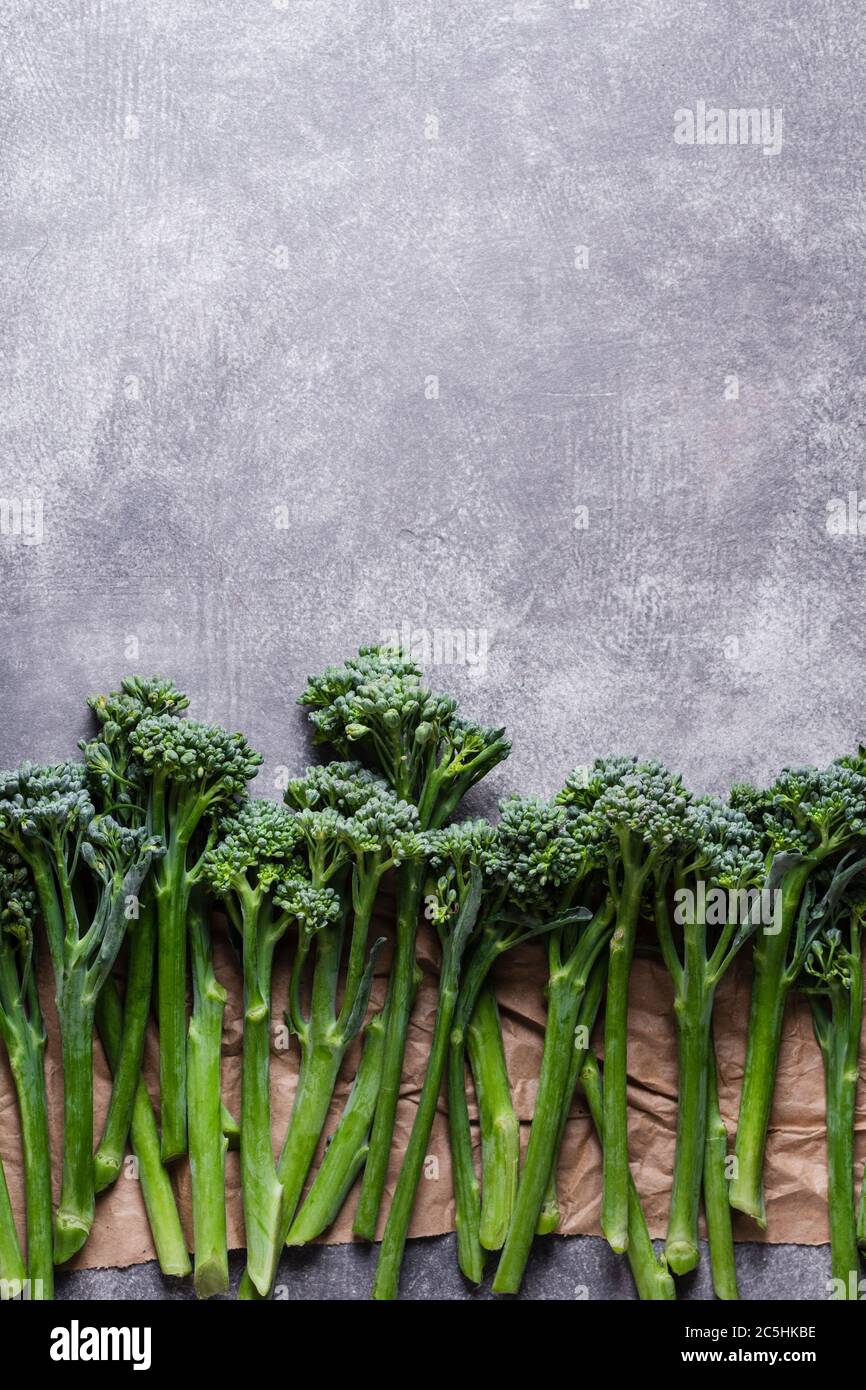 Fila di broccolini su fondo grigio in pietra. Vista dall'alto con spazio per la copia. Foto Stock