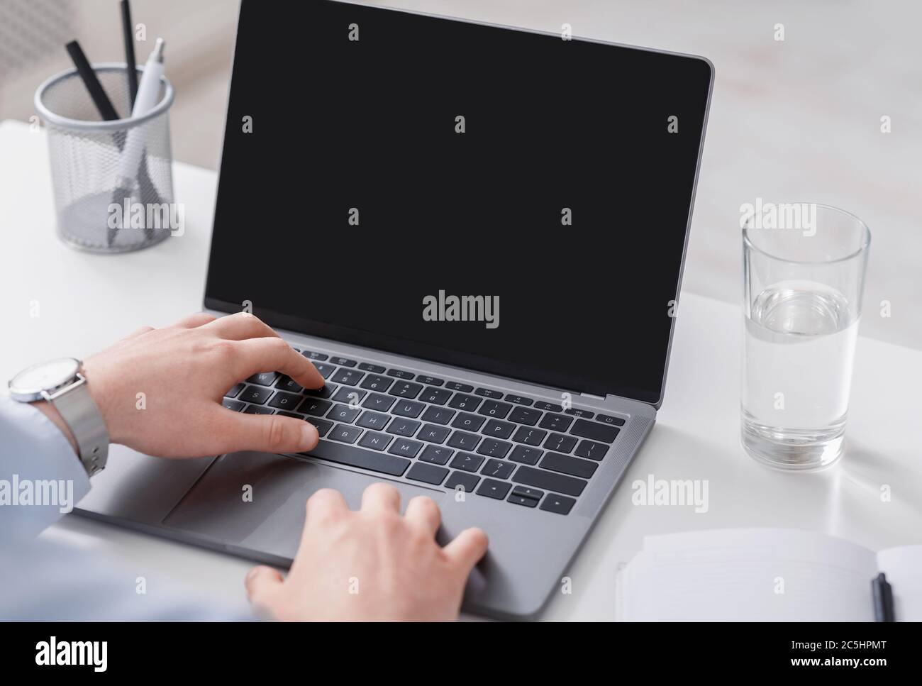 Mani di uomo d'affari che lavorano su un computer portatile con schermo vuoto Foto Stock