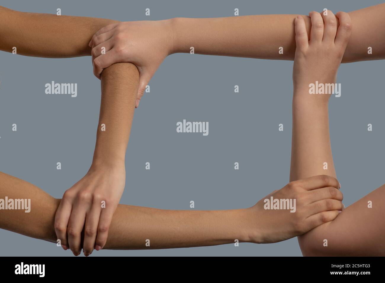 Primo piano di quattro mani di diverse razze che formano il quadrato Foto Stock