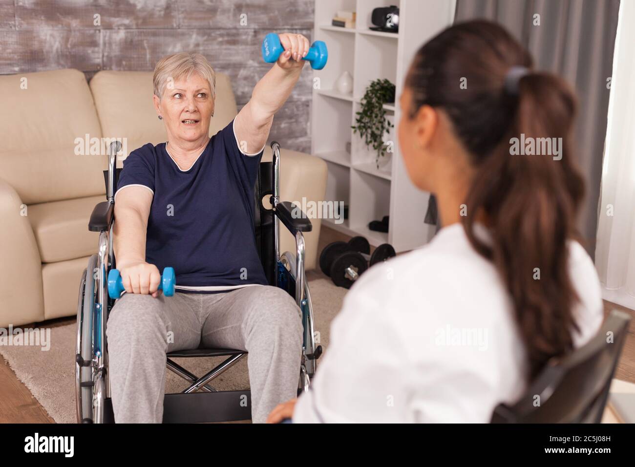 Trattamento di riabilitazione per anziana in carrozzina. Disabili anziani ricoverati infermiere professionista di aiuto, cura casa di riposo e riabilitazione Foto Stock
