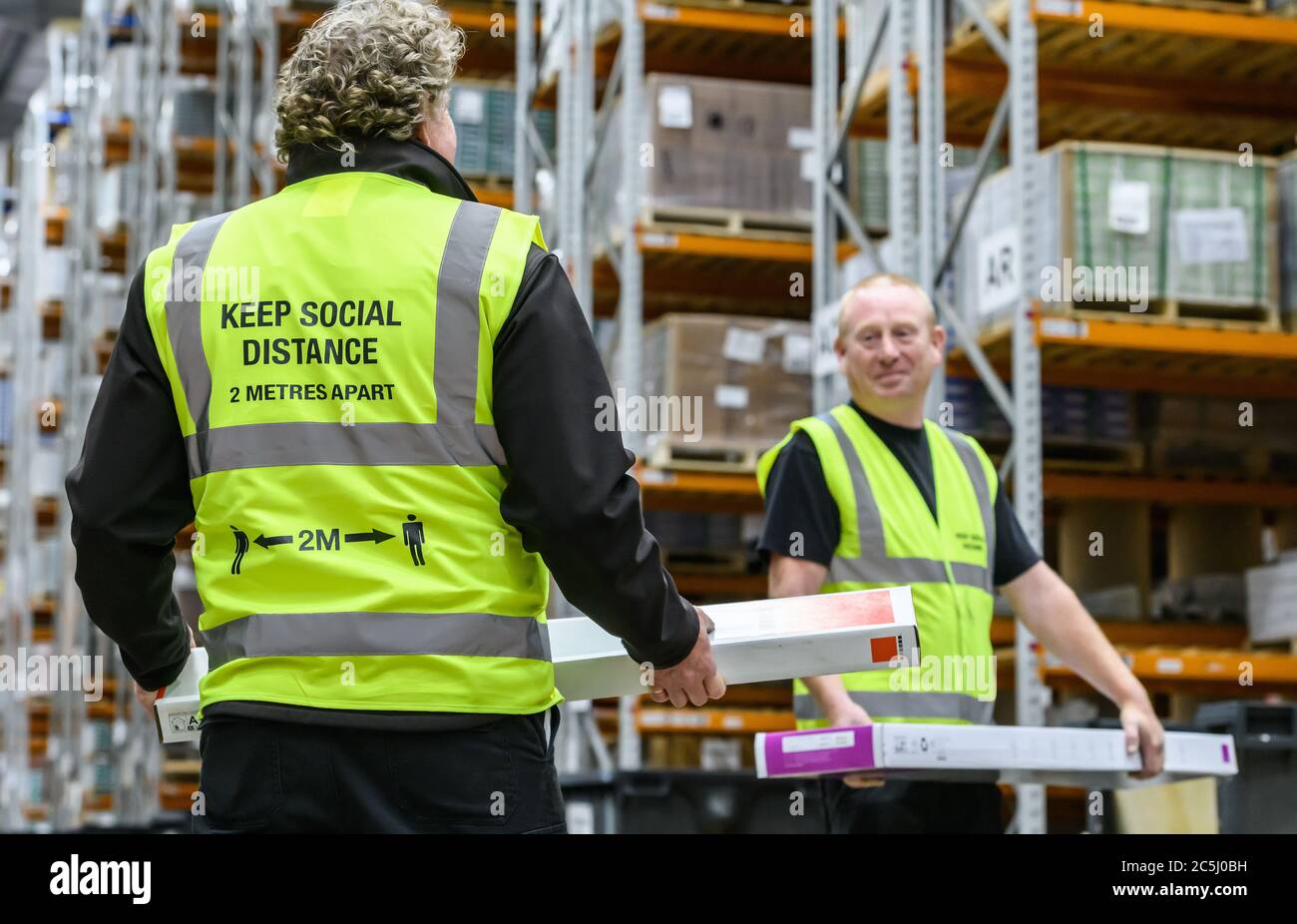 Lavoratori che rispettano le misure di allontanamento sociale post-lock in un magazzino a Evesham, Worcestershire, Inghilterra, Regno Unito. Foto Stock