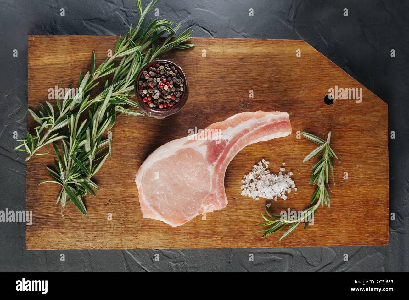 bistecca cruda preparata per cucinare e friggere su un tavolo di legno con cottura e spezie. Vista dall'alto Foto Stock