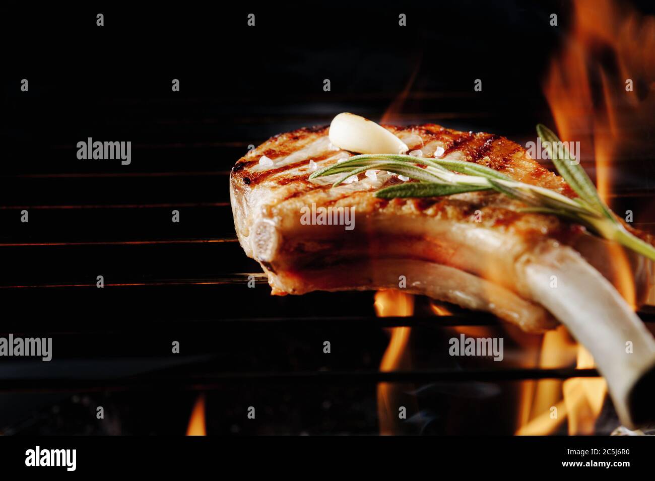 bistecca cotta con piatto da forno su griglia con fuoco su fondo nero con un posto per testo e iscrizioni. Primo piano Foto Stock