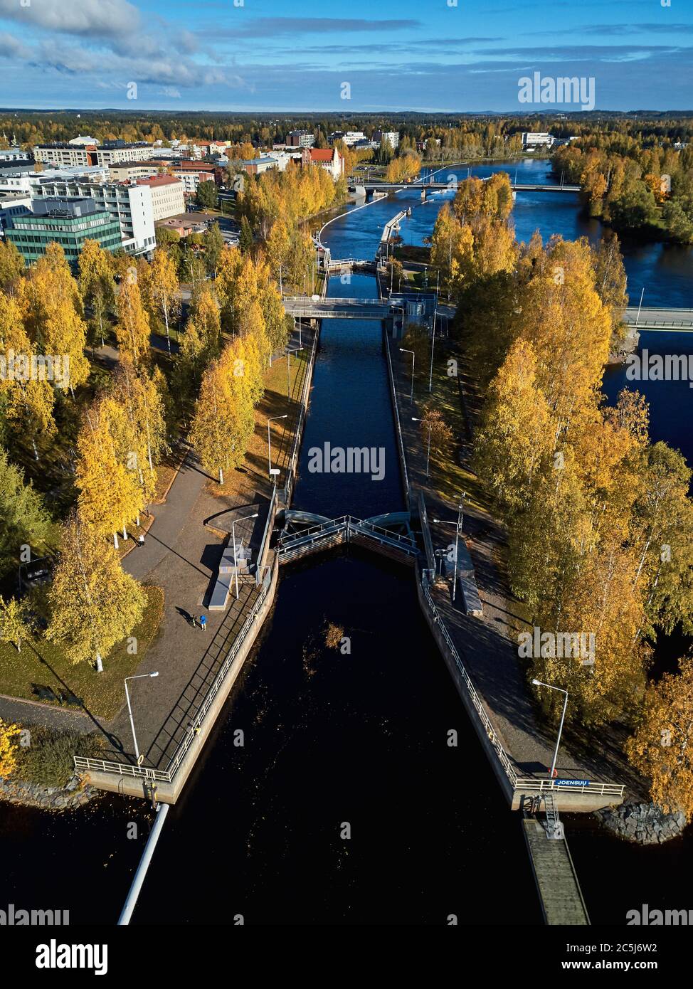 Vista aerea del canale di Joensuu e del fiume Pielisjoki. Bella città d'autunno con alberi giallo-arancio nel giorno del sole. Finlandia Foto Stock