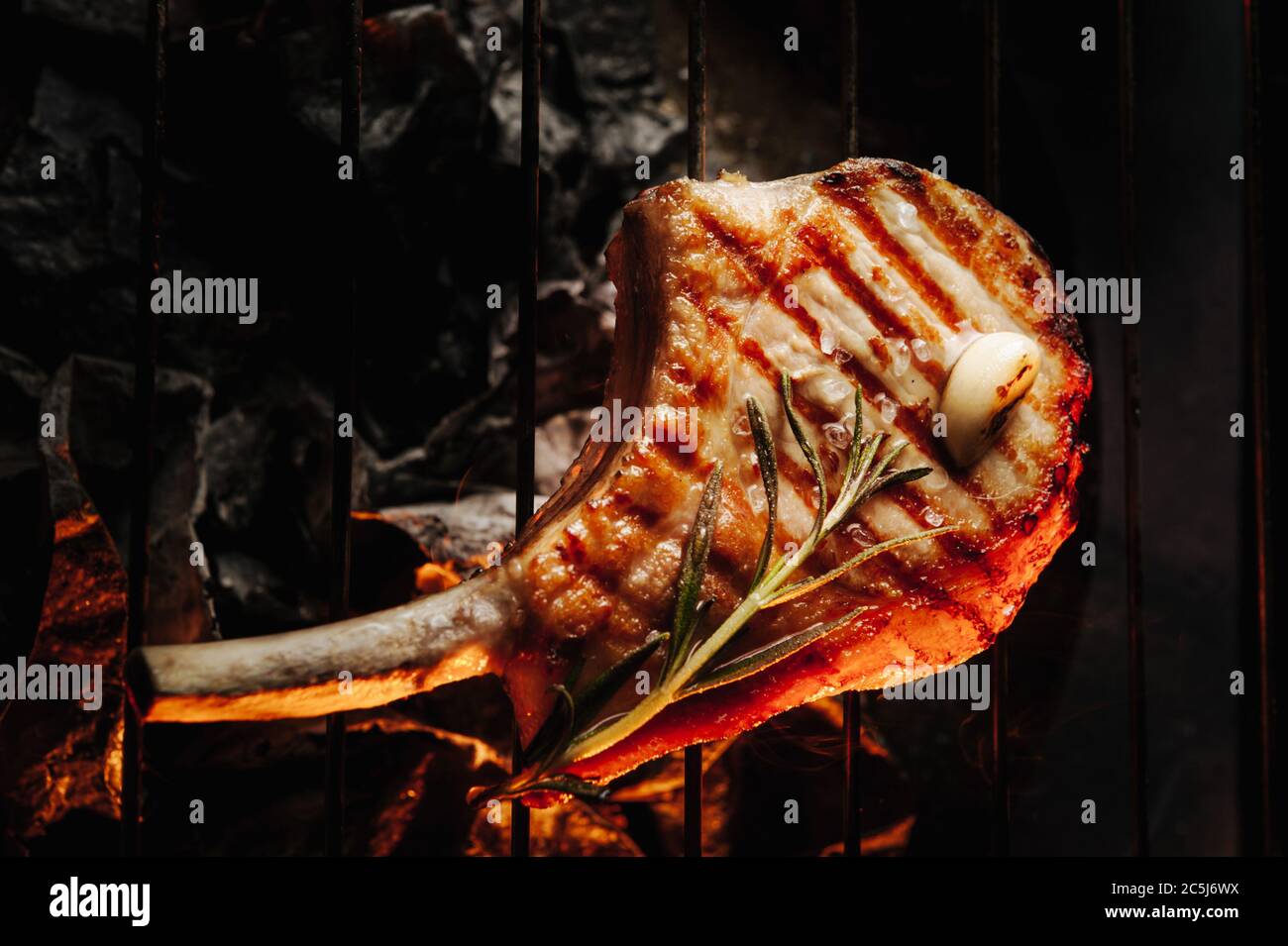 bistecca fritta all'osso con rosmarino e aglio alla griglia, bistecca di garchi con vista dall'alto fumosa Foto Stock