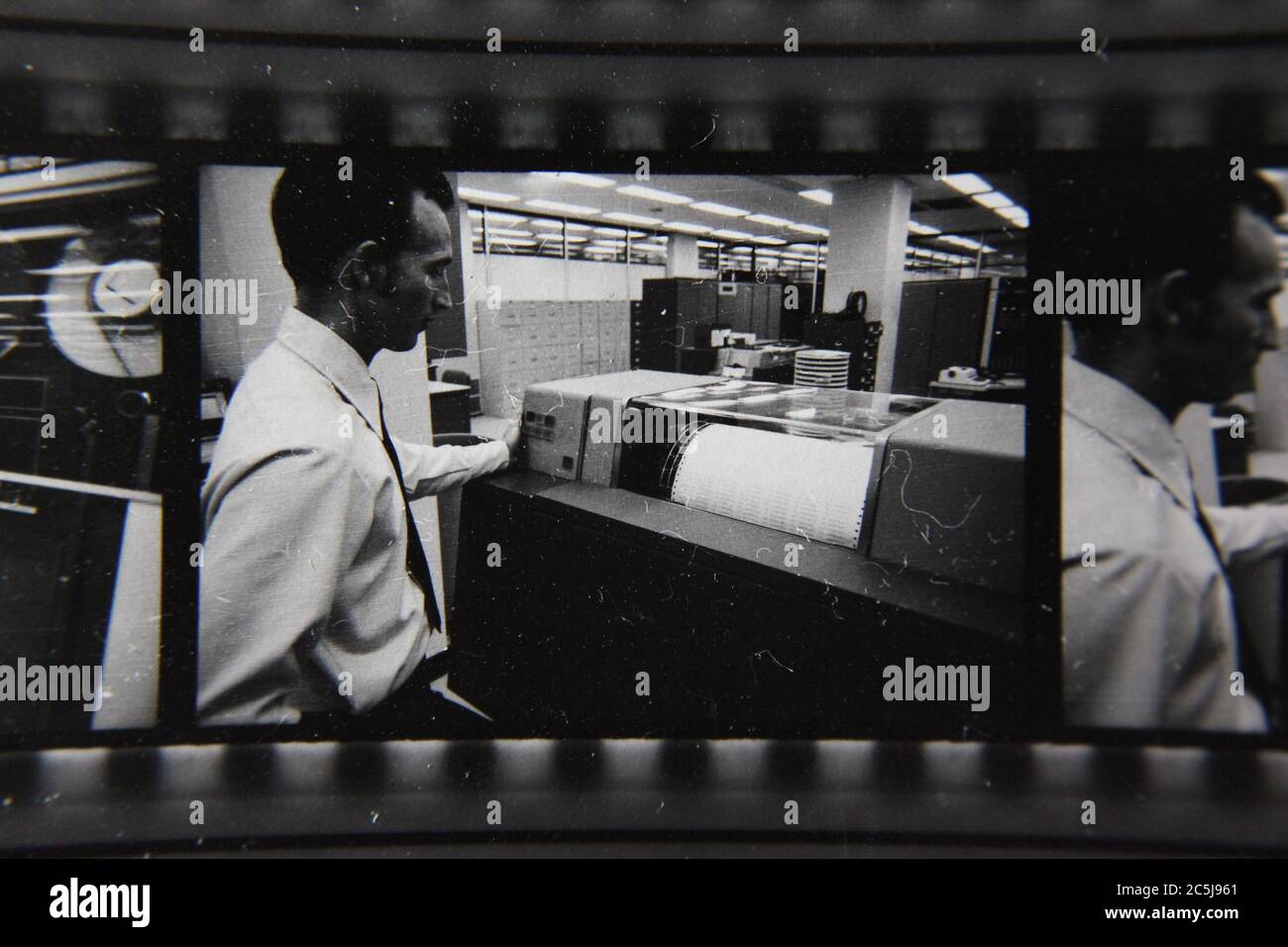 Fine anni '70 vintage contatto stampa in bianco e nero fotografia di un uomo che sovrintende un computer in una sala computer. Foto Stock