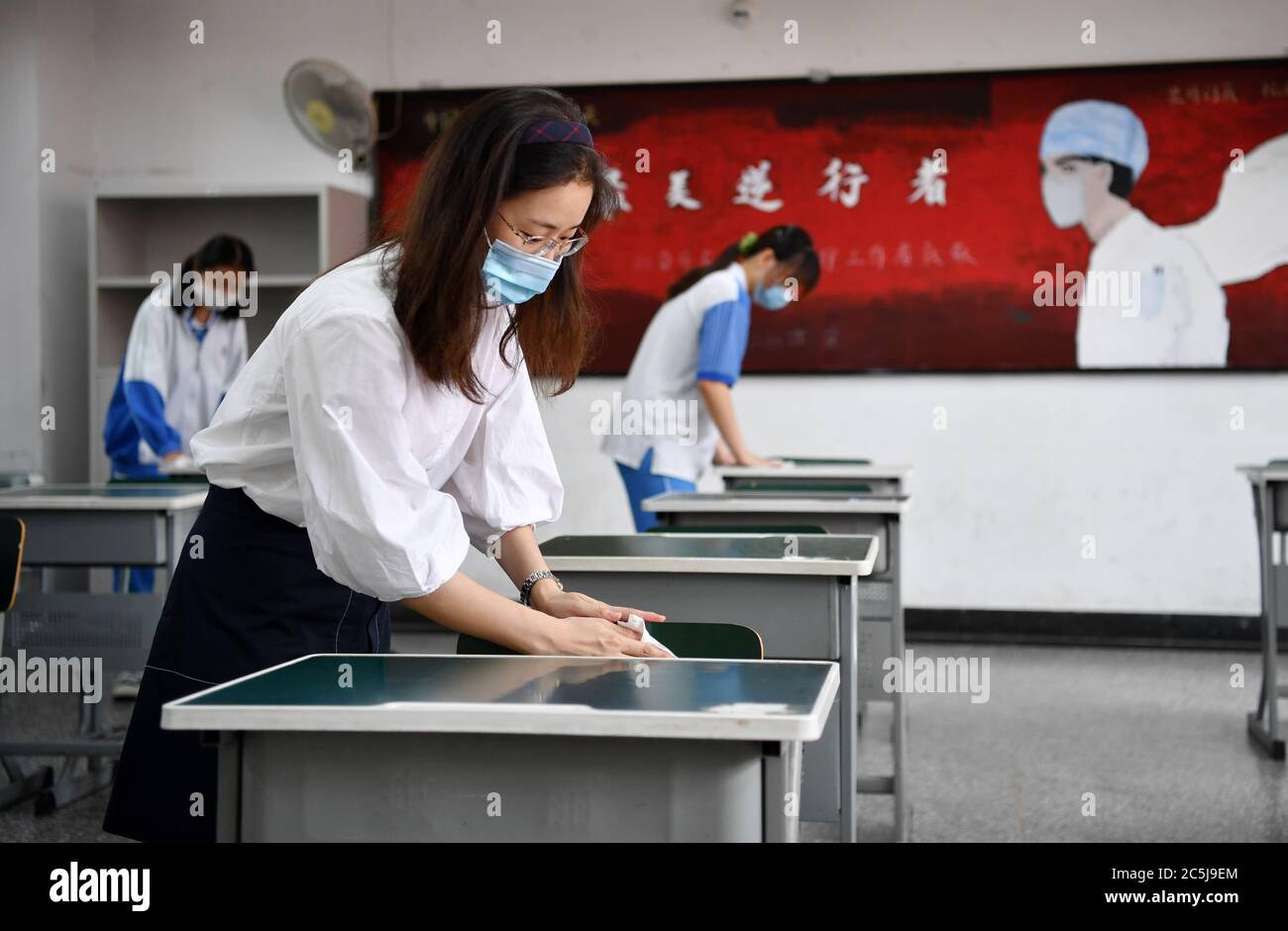 Pechino, Cina. 3 luglio 2020. Gli insegnanti disinfettano le scrivanie in una scuola media a Tianjin, Cina del nord, 3 luglio 2020. L'esame di ammissione al college nazionale di quest'anno in Cina inizierà dal 7 luglio. Per garantire la sicurezza e la salute dei candidati all'esame, sono necessarie severe misure anti-coronavirus in tutto il paese. Credit: Li Ran/Xinhua/Alamy Live News Foto Stock