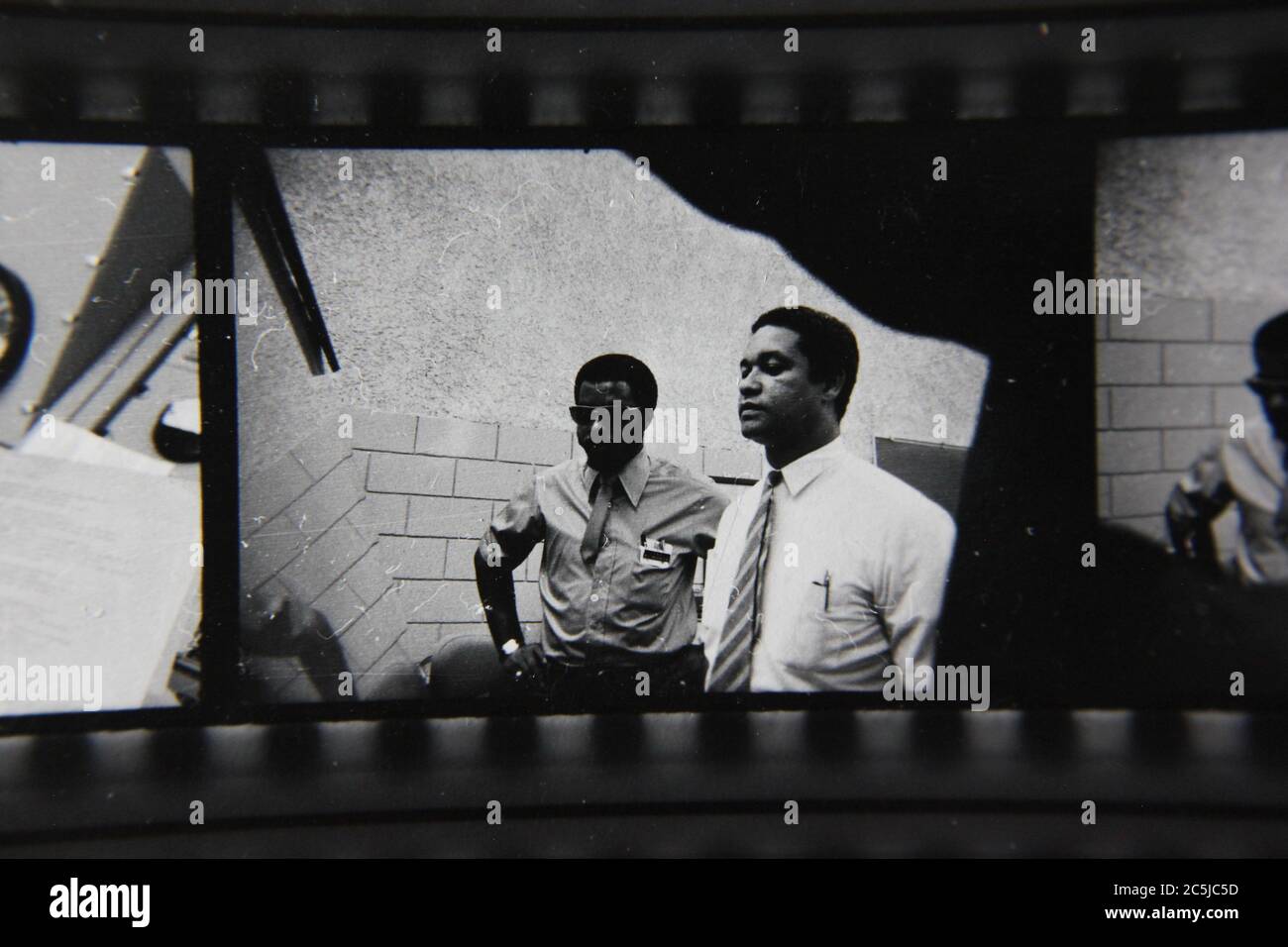Fine anni '70 vintage contatto stampa in bianco e nero fotografia di due uomini che hanno una discussione sul posto di lavoro. Foto Stock