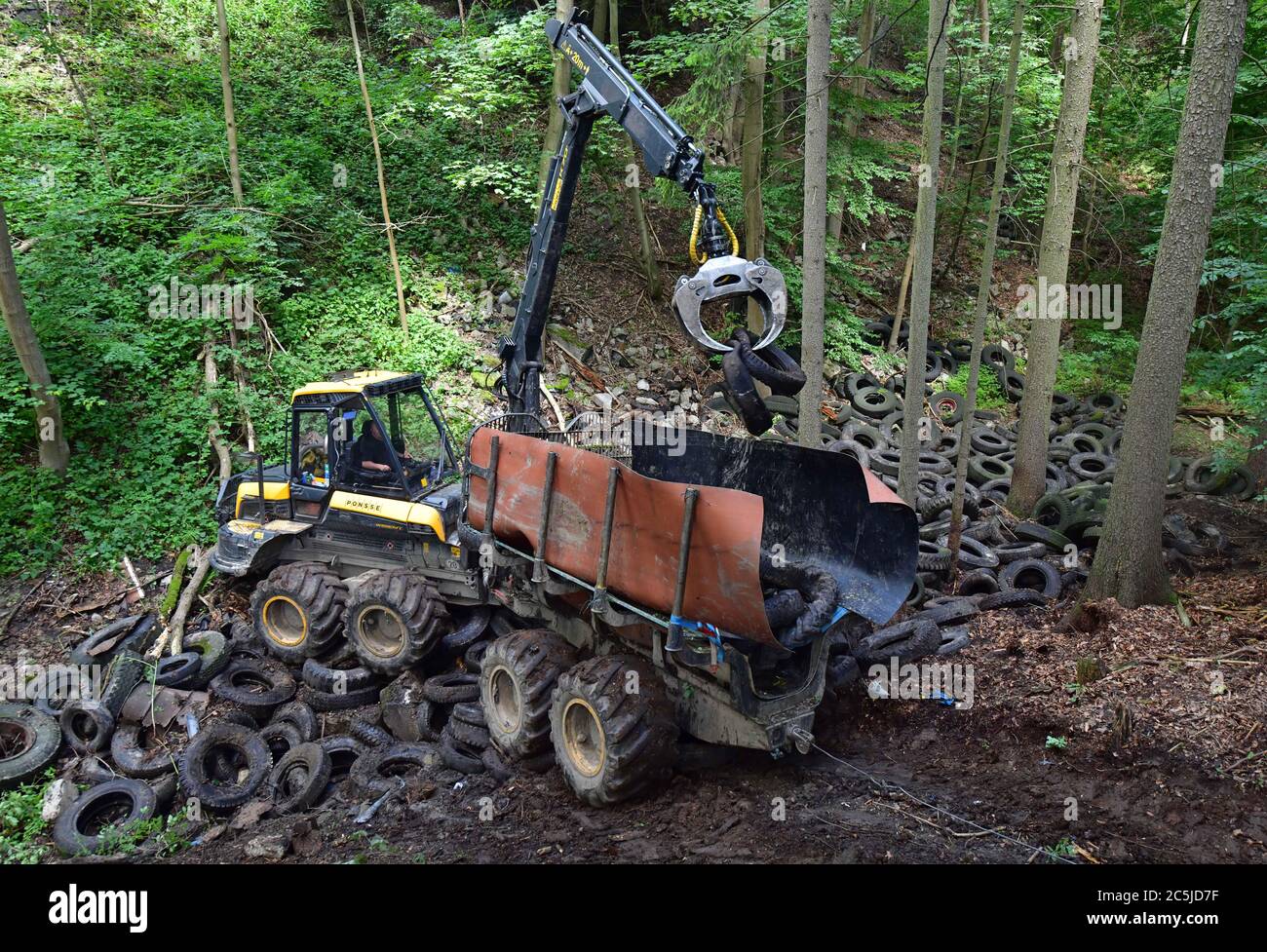 Schorba, Germania. 03 luglio 2020. La tecnologia pesante viene utilizzata per rimuovere un sito di discarica contaminato con circa 1500 pneumatici. Nella Valle di Leutra, sono iniziati i lavori di discarica per pneumatici usati, ben noti nel paese. I costi ammontano a circa 50,000 Euro. Il ministero ha detto che la zona forestale era stata usata come discarica di rifiuti selvatici dalla metà degli anni '50. Credit: Martin Schutt/dpa/Alamy Live News Foto Stock