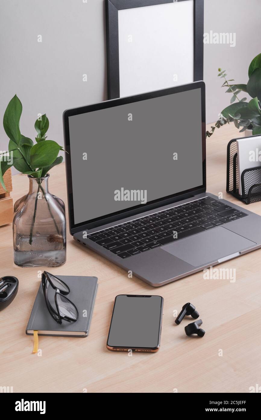 Telefono cellulare minimale per l'ufficio, con scrivania in legno e grigio mockup parete Foto Stock