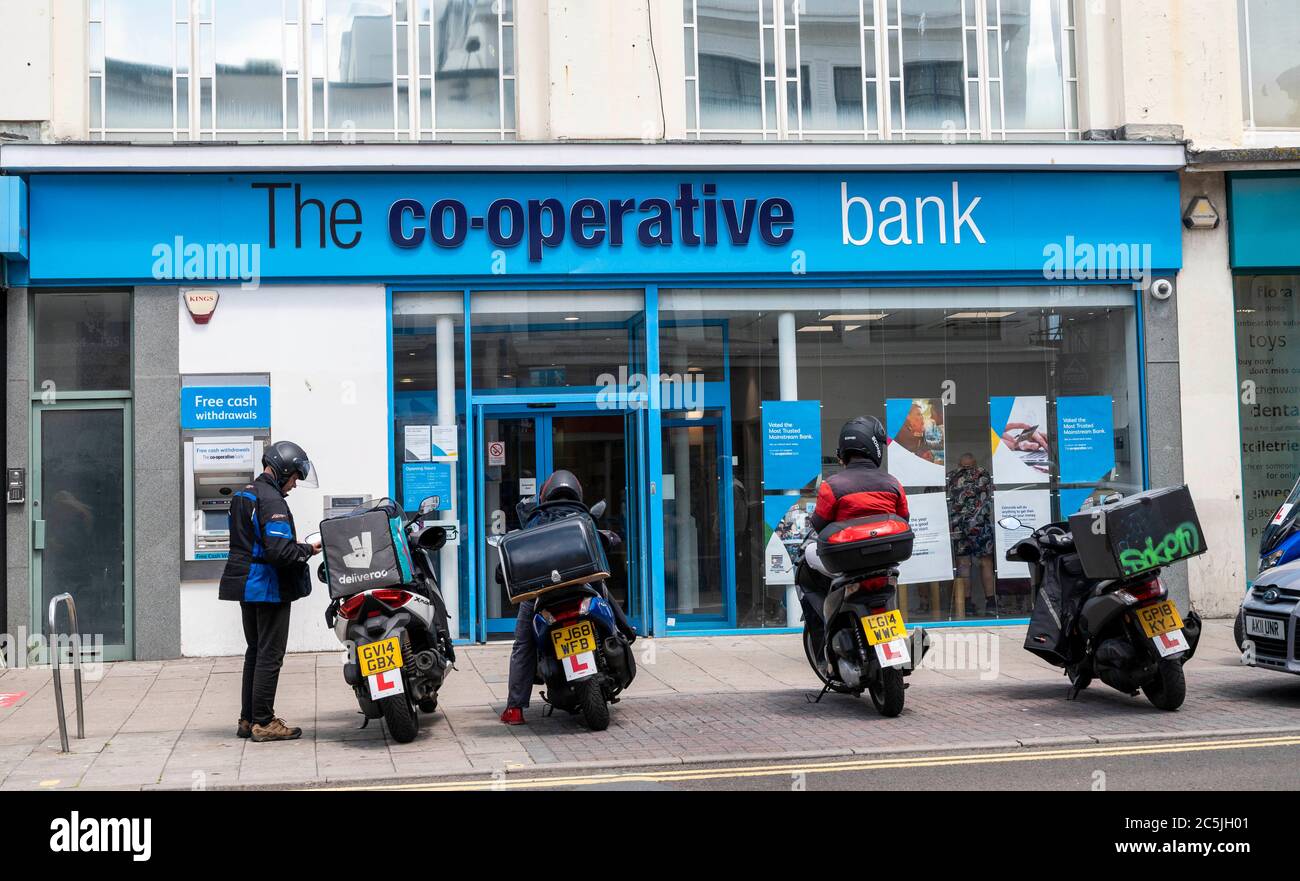 La banca cooperativa di Western Road Brighton con conducente di scooter con consegna rapida di cibo fuori dal Regno Unito Foto Stock