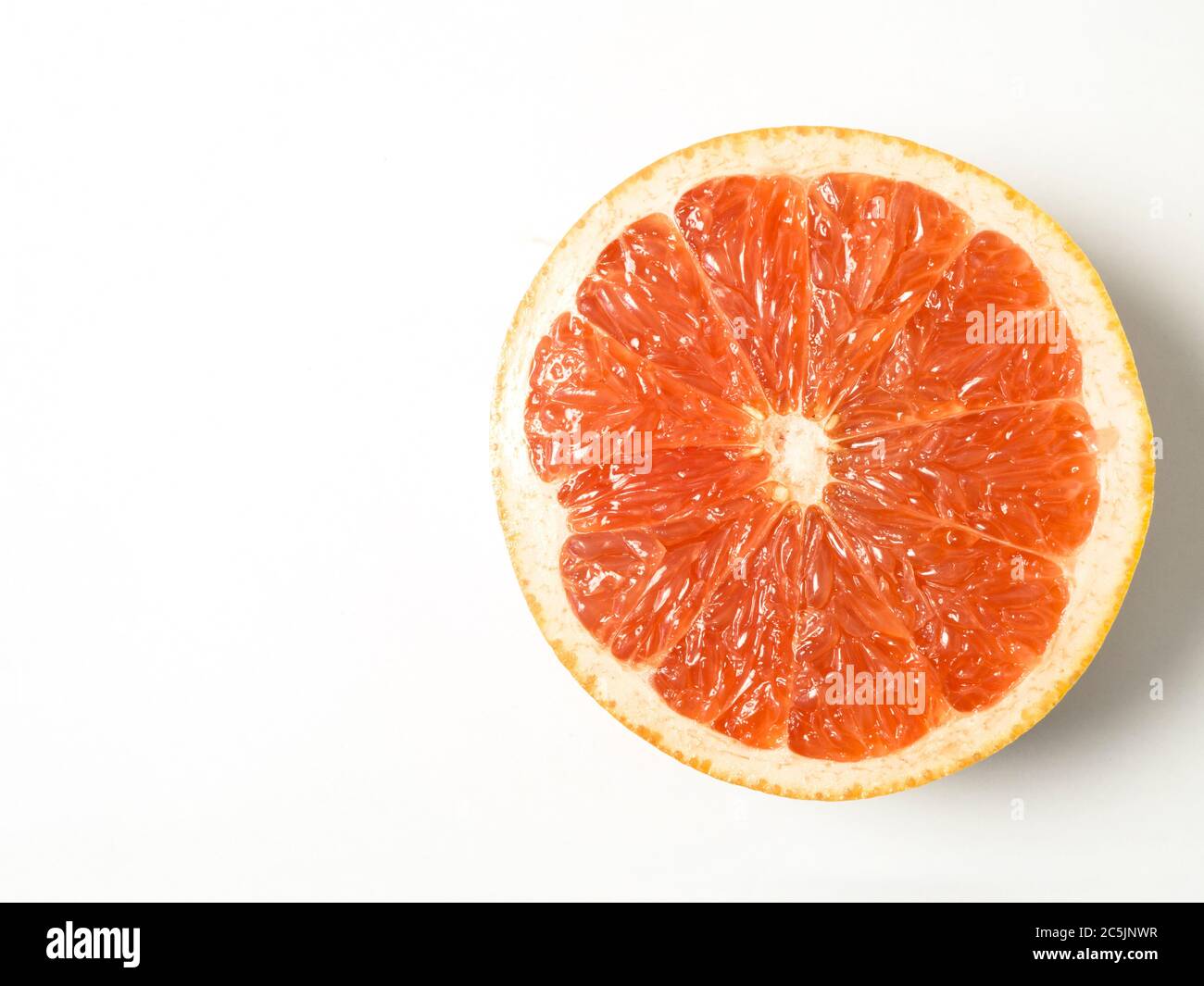 Mezzo grapefuit rosa isolato su sfondo bianco con spazio di copia Foto Stock