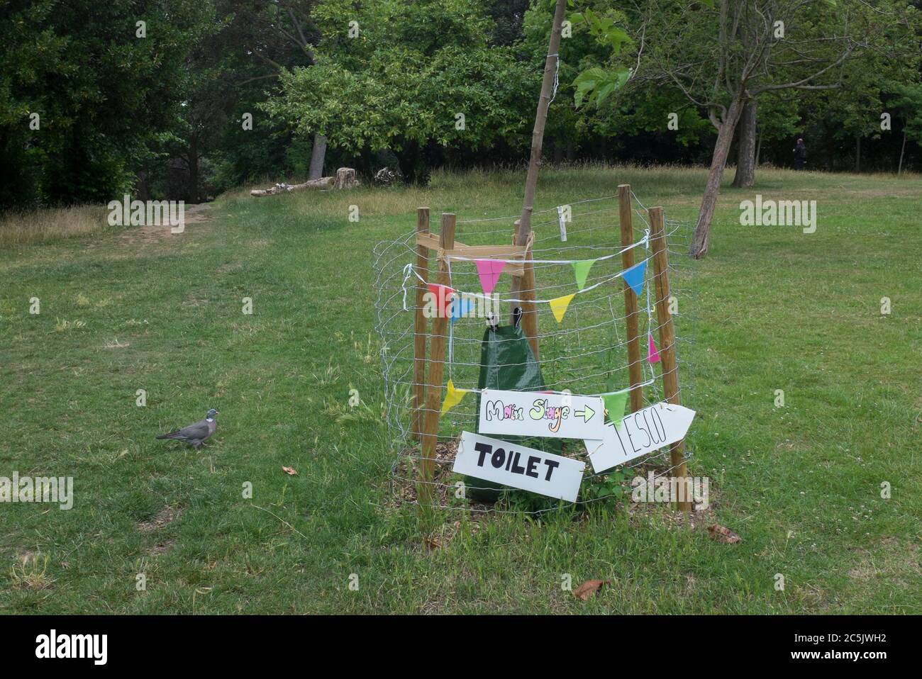 Mentre le comodita' del parco sono ancora chiuse, i cartelli di fortuna che indicano dove si trovano i servizi igienici vicini durante il blocco pandemico di Coronavirus sono, sono attaccati alla recinzione protettiva intorno ad un albero del yourg nel Parco Ruskin, Lambeth, il 30 Giugno 2020, a Londra, Inghilterra. Foto Stock