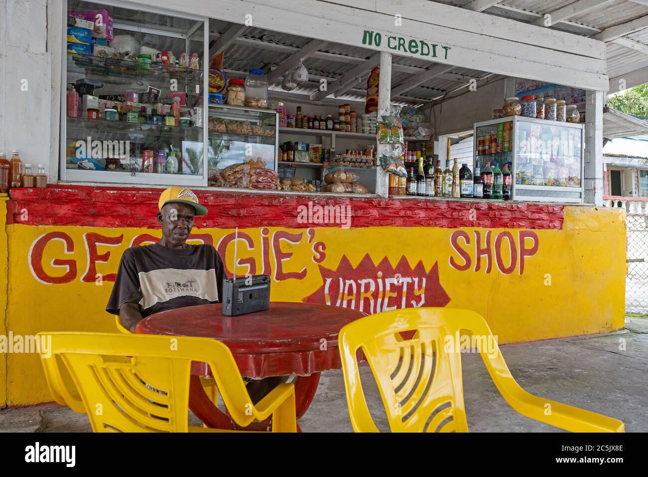 Negoziante di fronte al piccolo negozio di alimentari, Isole Essequibo-Regione Demerara Ovest, Guyana, Sud America Foto Stock