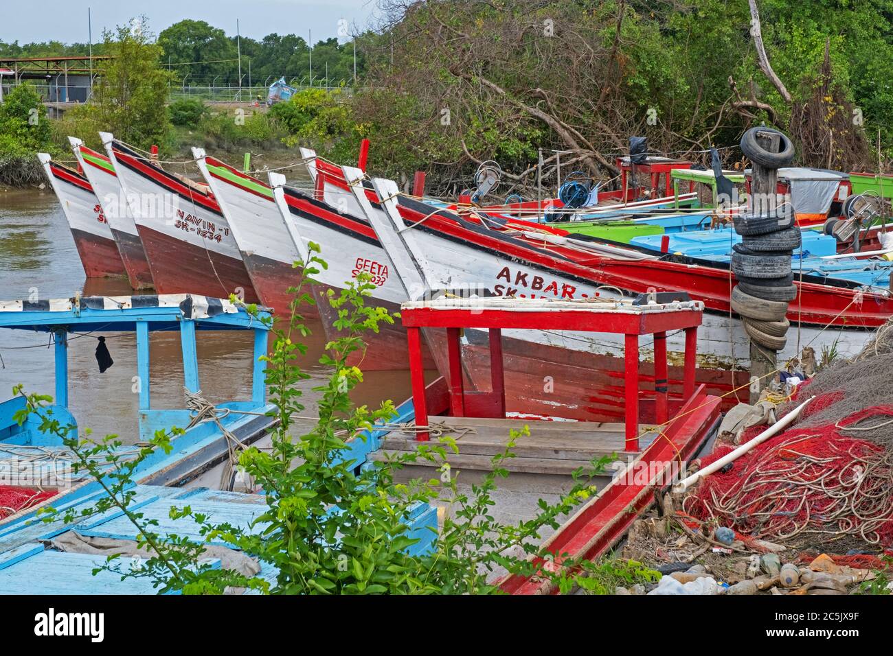 Colorate barche da pesca tradizionali in legno ormeggiate lungo la costa della Guyana, in Sud America Foto Stock