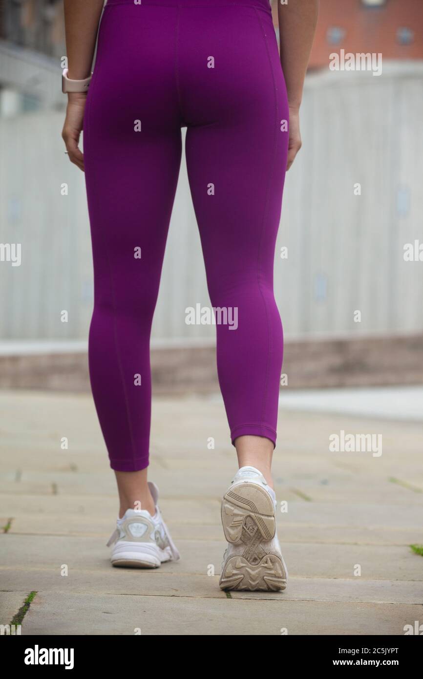 Vista posteriore ad angolo basso di una donna che indossa leggings e scarpe da ginnastica. Foto Stock