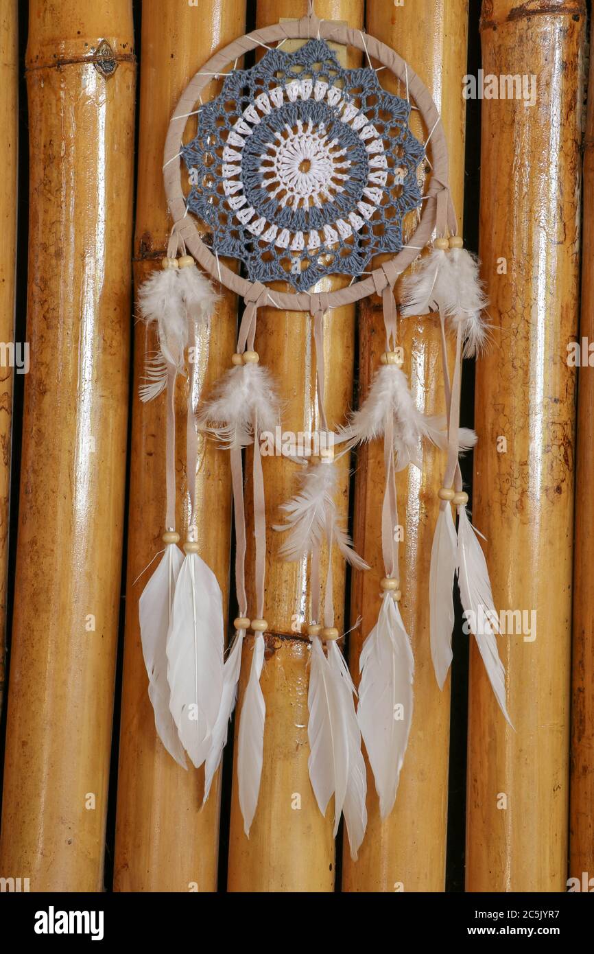 Blue Dreamcatcher con piume e perline isolate su uno sfondo wodden. Foto Stock