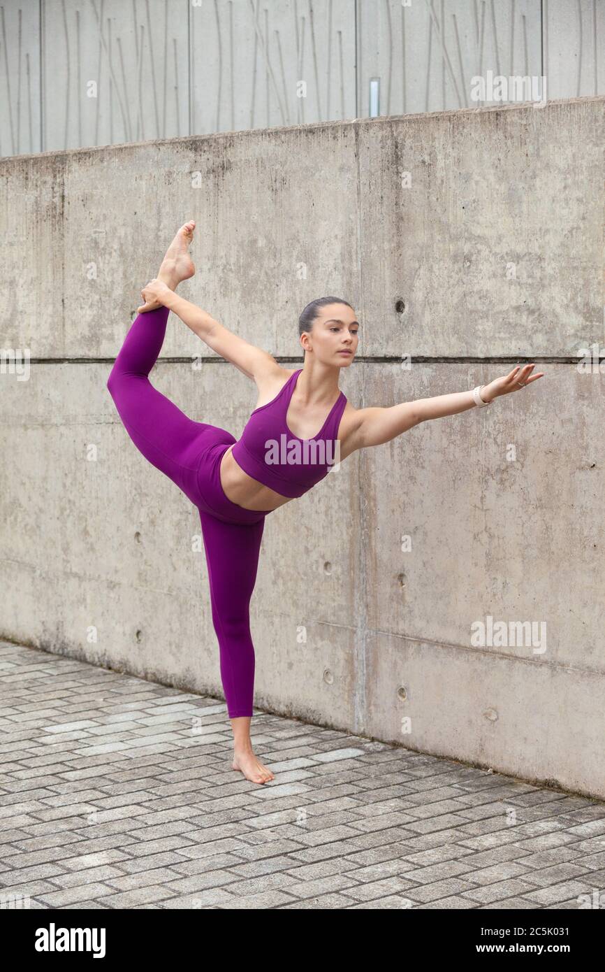 Donna che indossa abbigliamento sportivo che si allunga le gambe dopo un allenamento Foto Stock