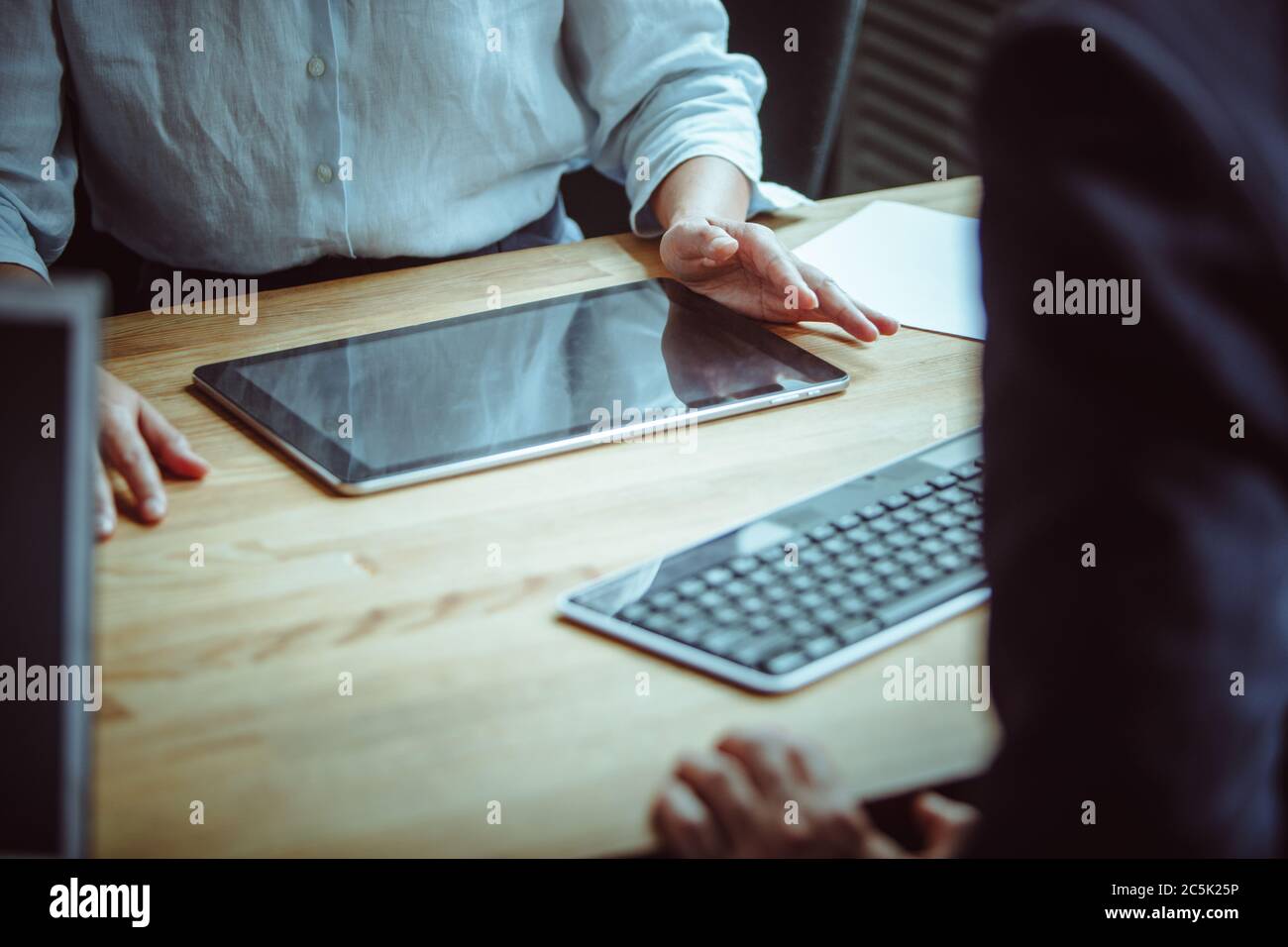Uomo e donna hanno conversazione in riunione di affari. Concetto di comunicazione aziendale. Primo piano di mani maschili e femminili sul tavolo con il digitale Foto Stock Uomo e donna hanno conversazione in riunione di affari. Concetto di comunicazione aziendale. Primo piano di mani maschili e femminili sul tavolo con il digitale Foto Stock