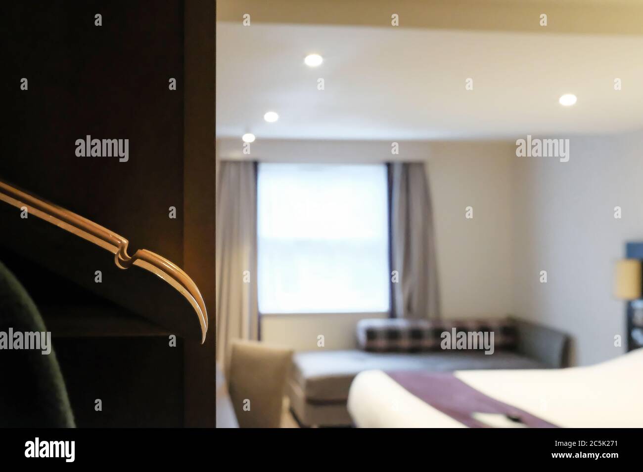 Il punto focale di un set di appendiabiti in legno visto in una sezione guardaroba in una moderna camera d'hotel a prezzi premium. Foto Stock