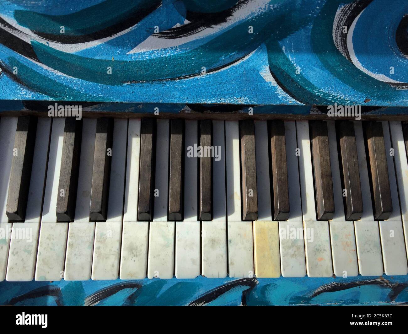 Pianoforte blu dipinto e artistico con primo piano di chiavi. Foto Stock